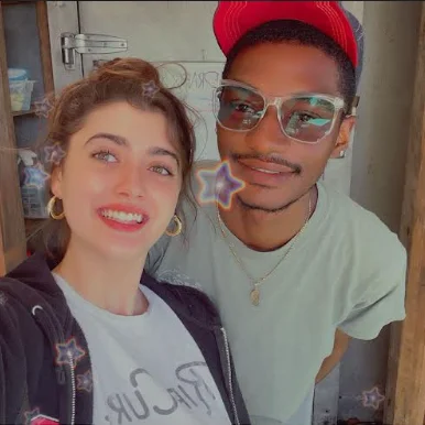 Two friends smiling for a selfie in a rustic setting