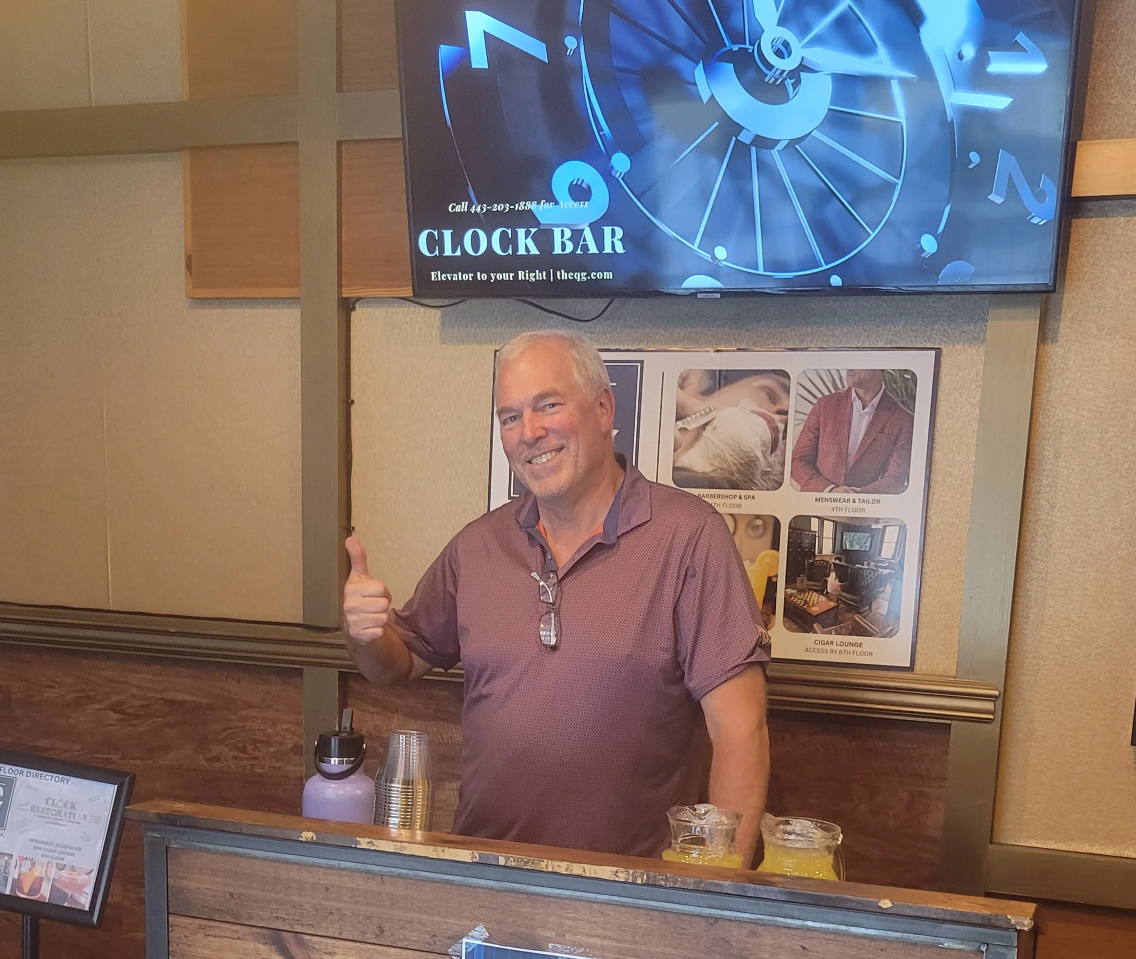 Friendly bartender at Clock Bar with modern decor and a digital clock display