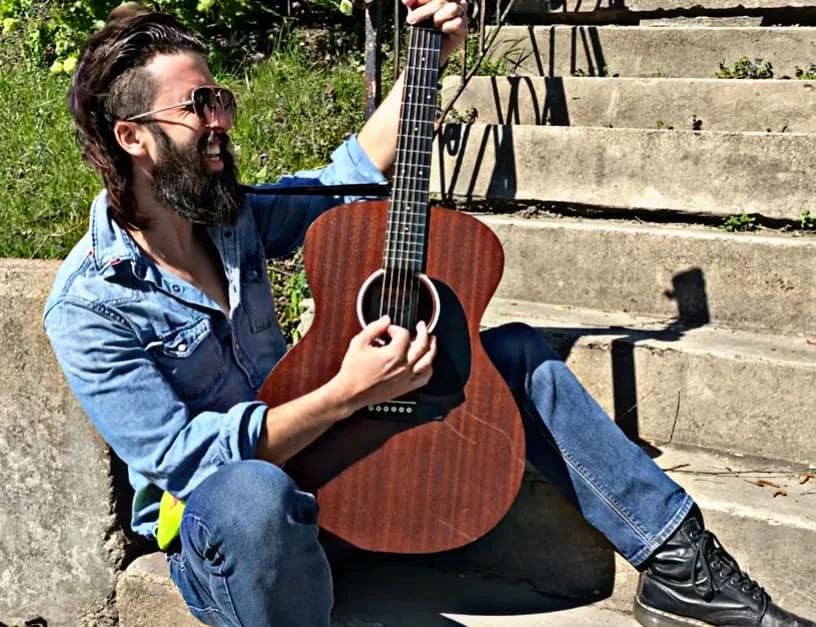 Musician playing guitar on outdoor steps