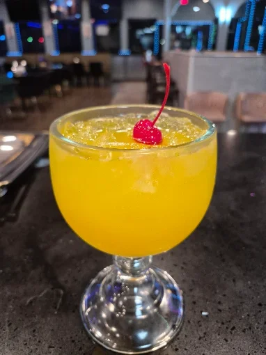 Vibrant tropical cocktail garnished with a cherry in a glass