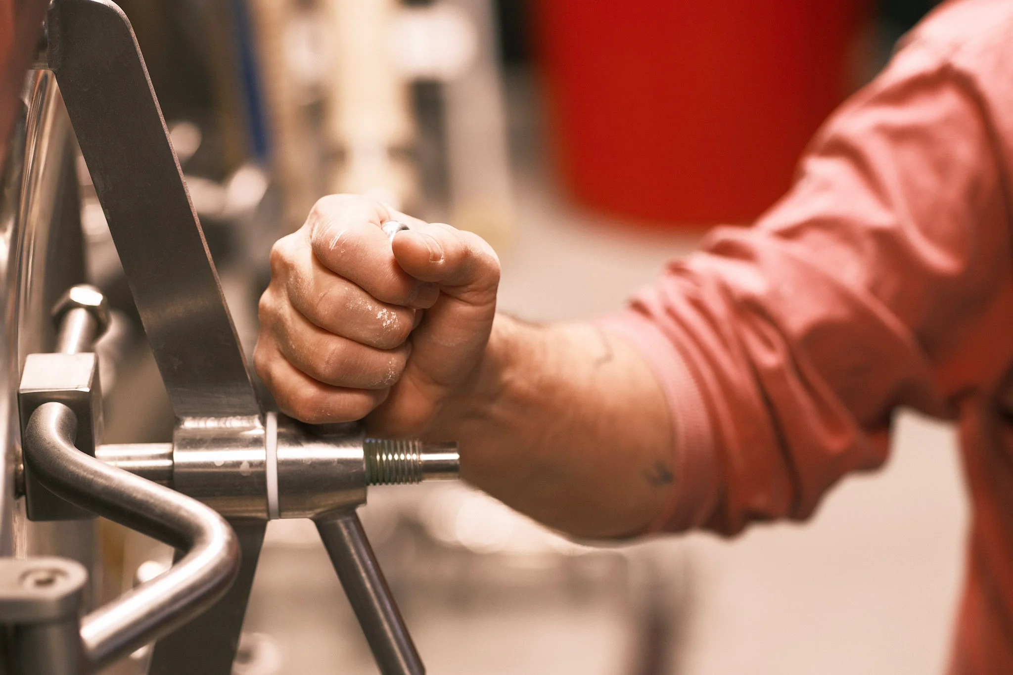 Close-up of a hand adjusting a metal machine component