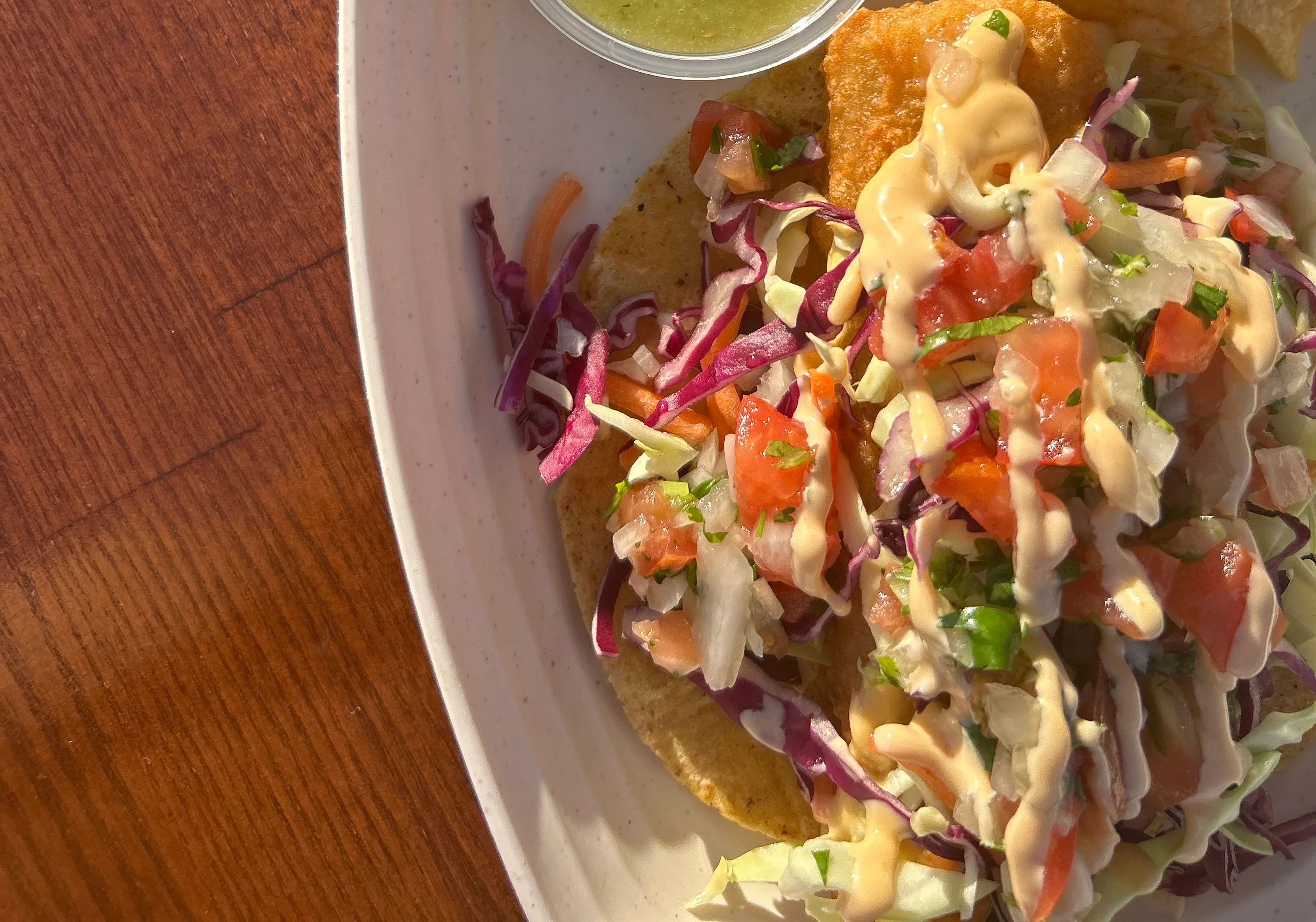 Crispy fish tacos with fresh toppings and salsa verde