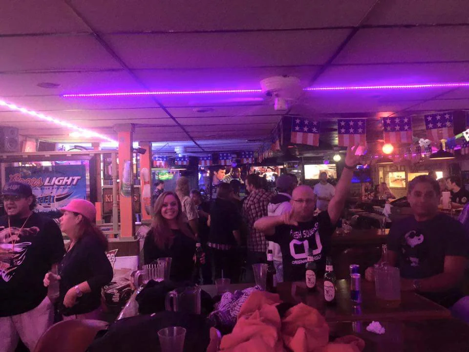 Vibrant bar scene with patrons enjoying drinks and lively atmosphere