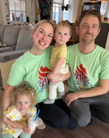 Family posing together in matching green shirts at home
