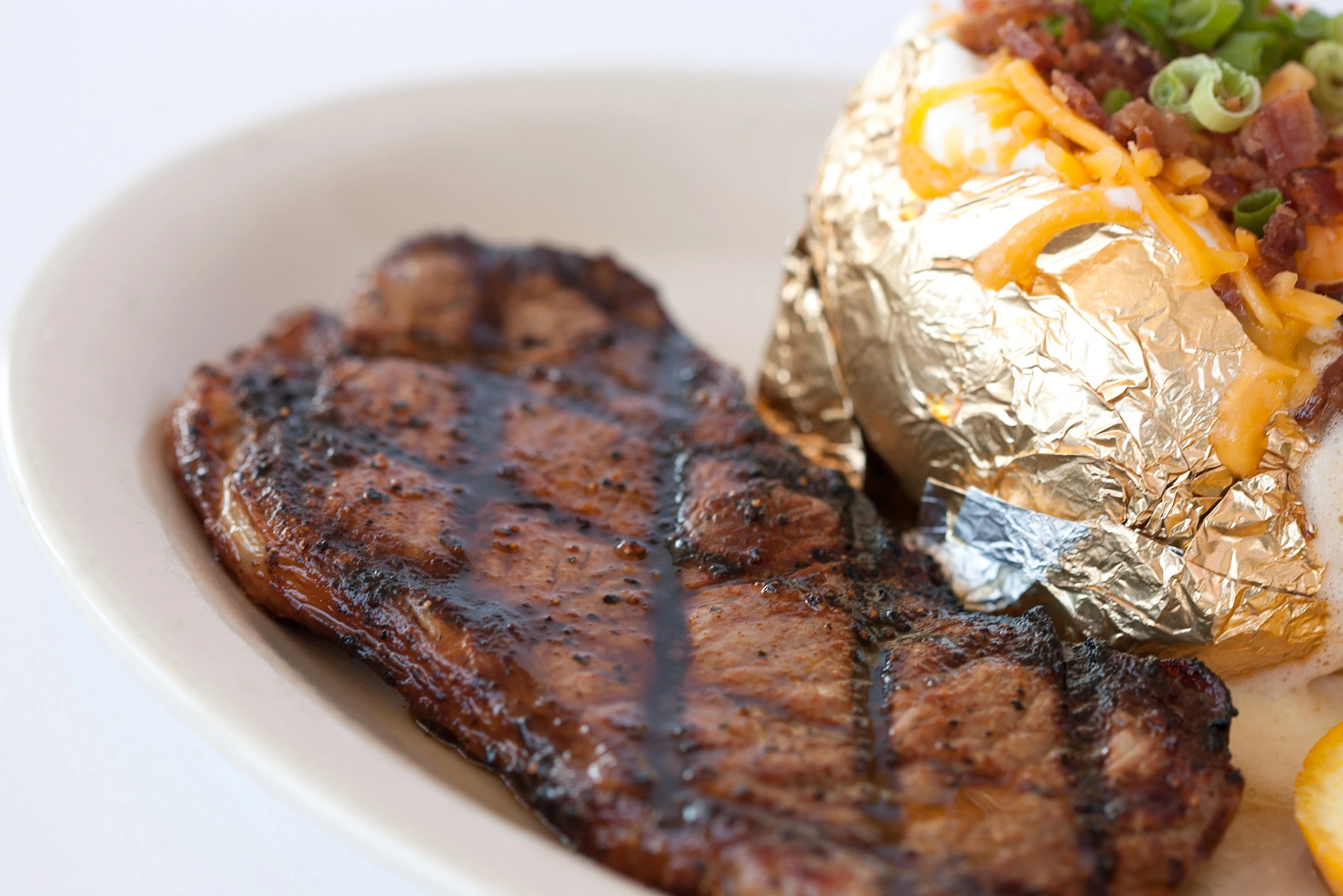 Grilled steak with a loaded baked potato
