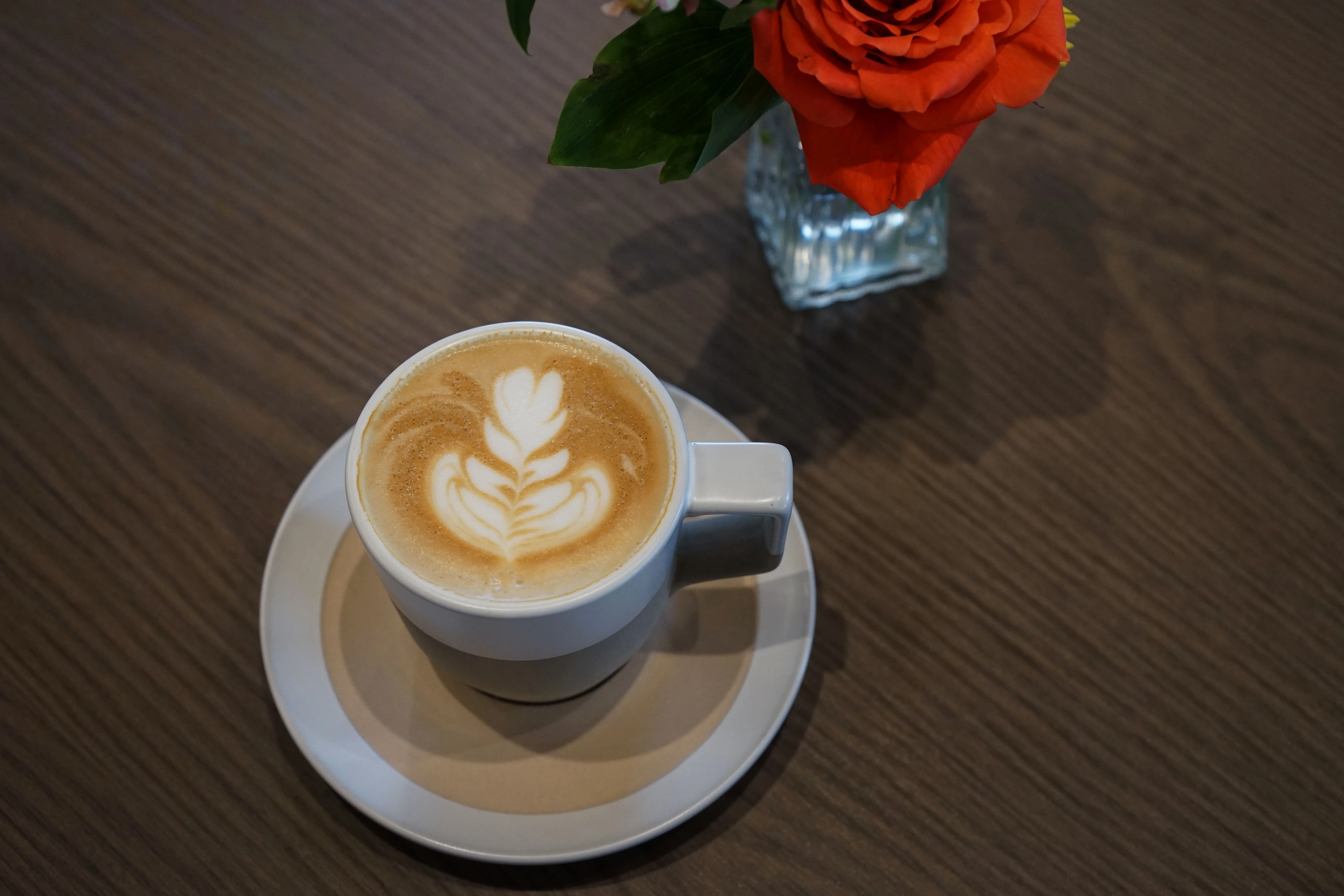 Artisan latte with intricate foam art on a wooden table