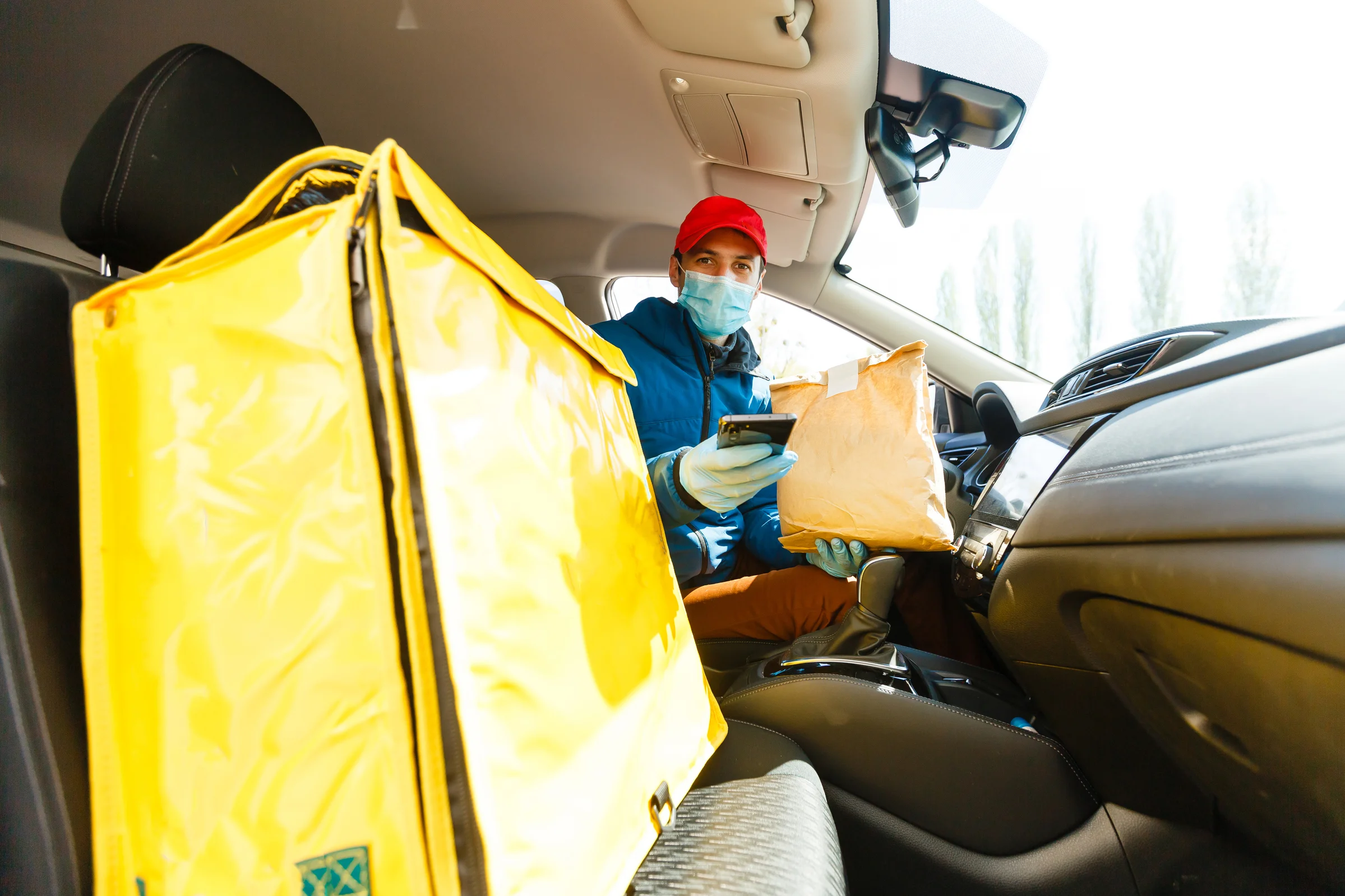 Delivery driver preparing food orders in a car