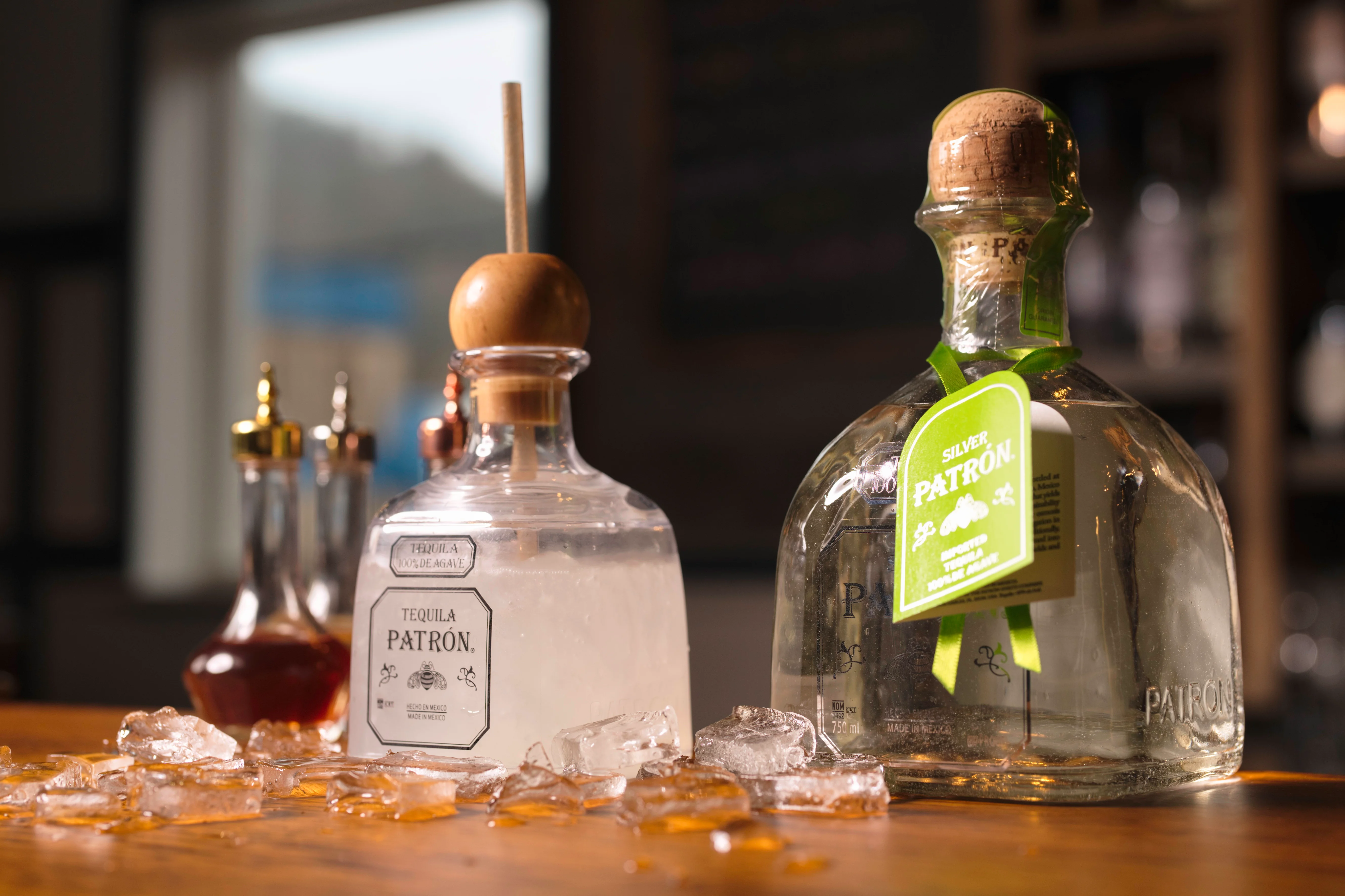 Premium tequila bottles on a wooden bar with ice