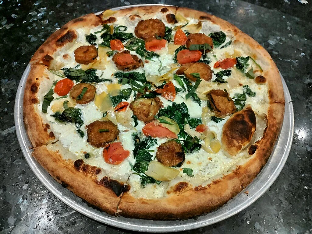 Vegetarian pizza with fresh greens and artichokes