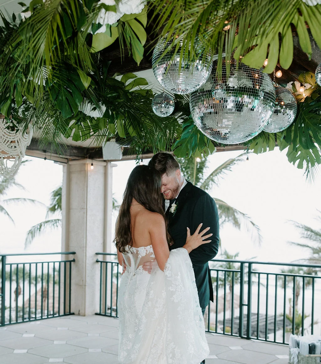 Couple sharing a romantic moment at a wedding venue with tropical decor