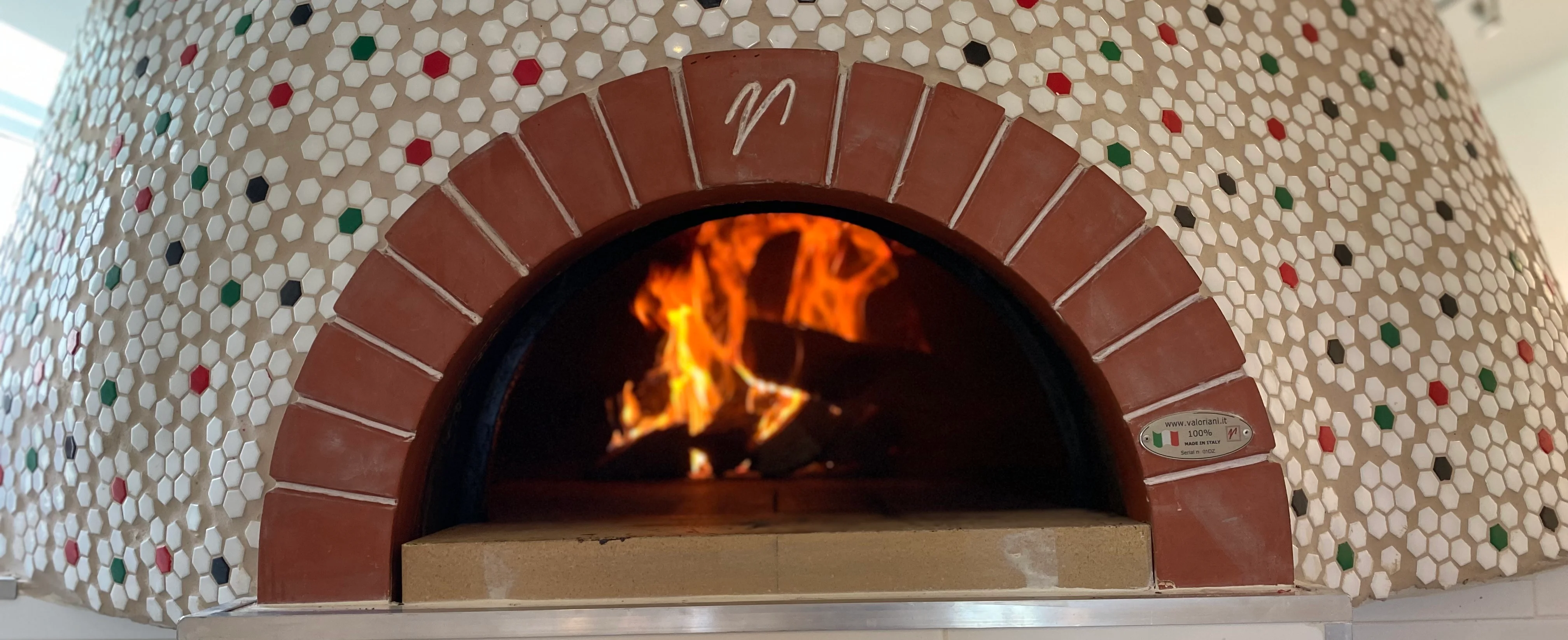 Wood-fired pizza oven with vibrant tile design