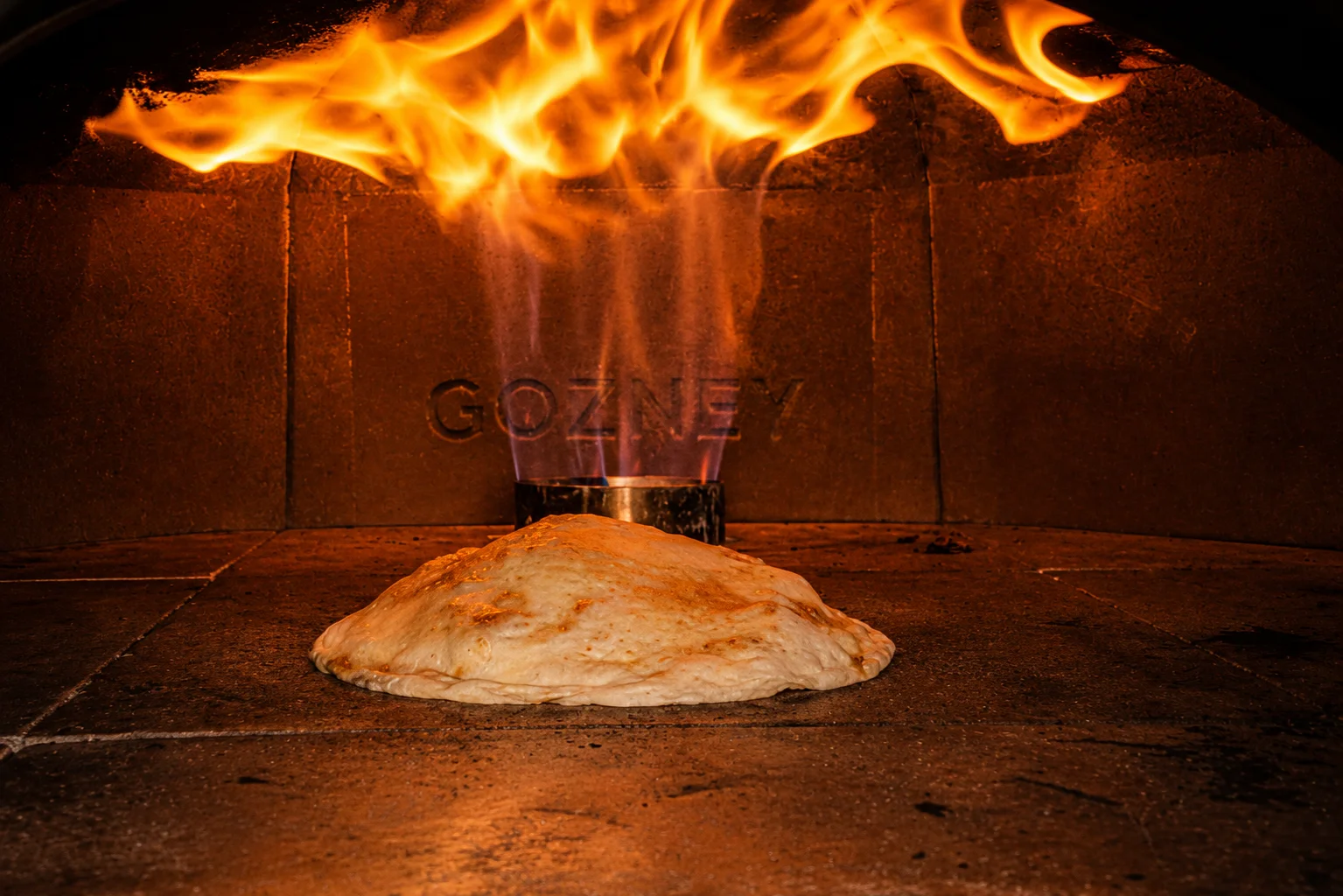 Wood-fired naan baking in a traditional oven