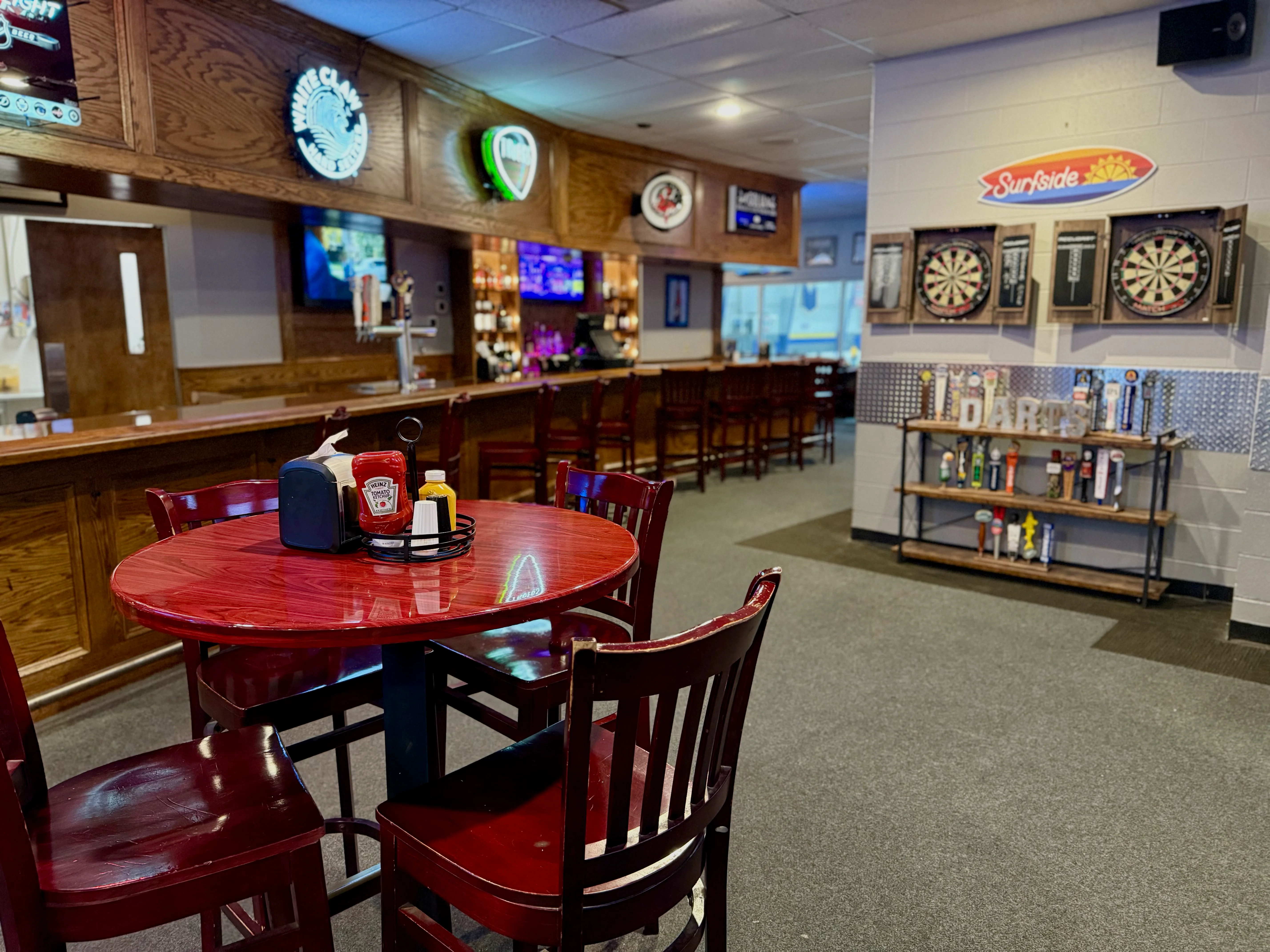 Cozy restaurant interior with bar and dartboard area
