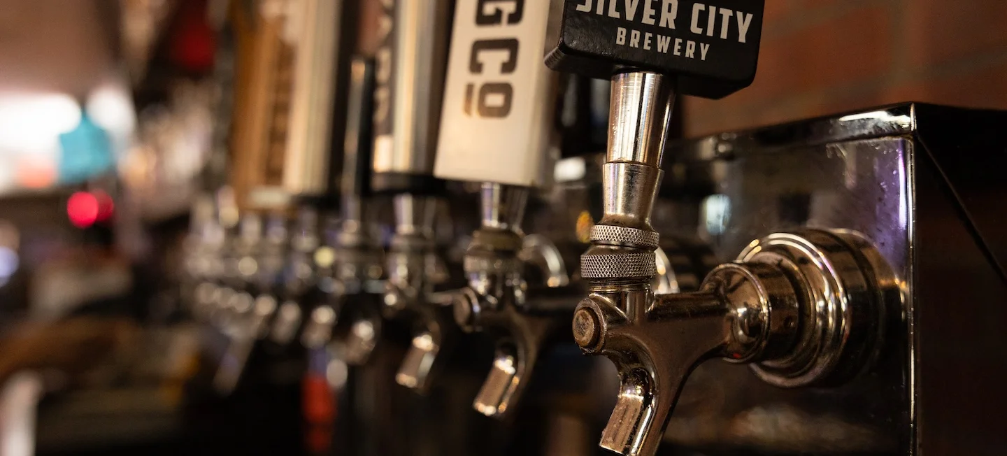 Craft beer taps at a lively bar counter