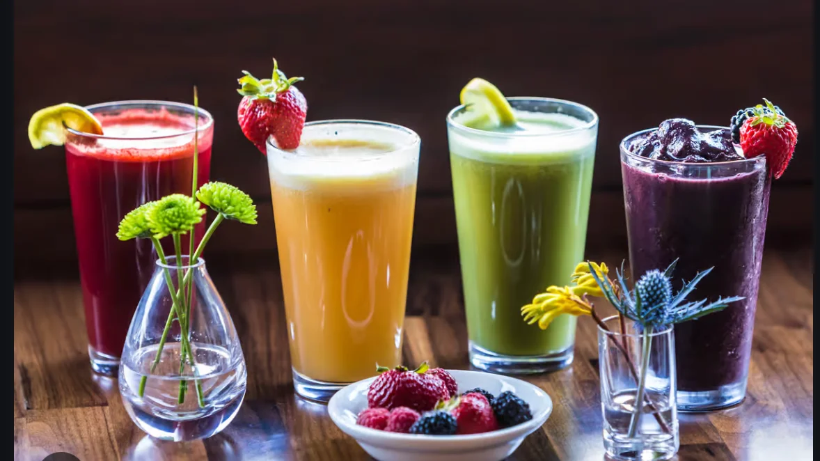 Colorful assortment of fresh fruit juices in tall glasses