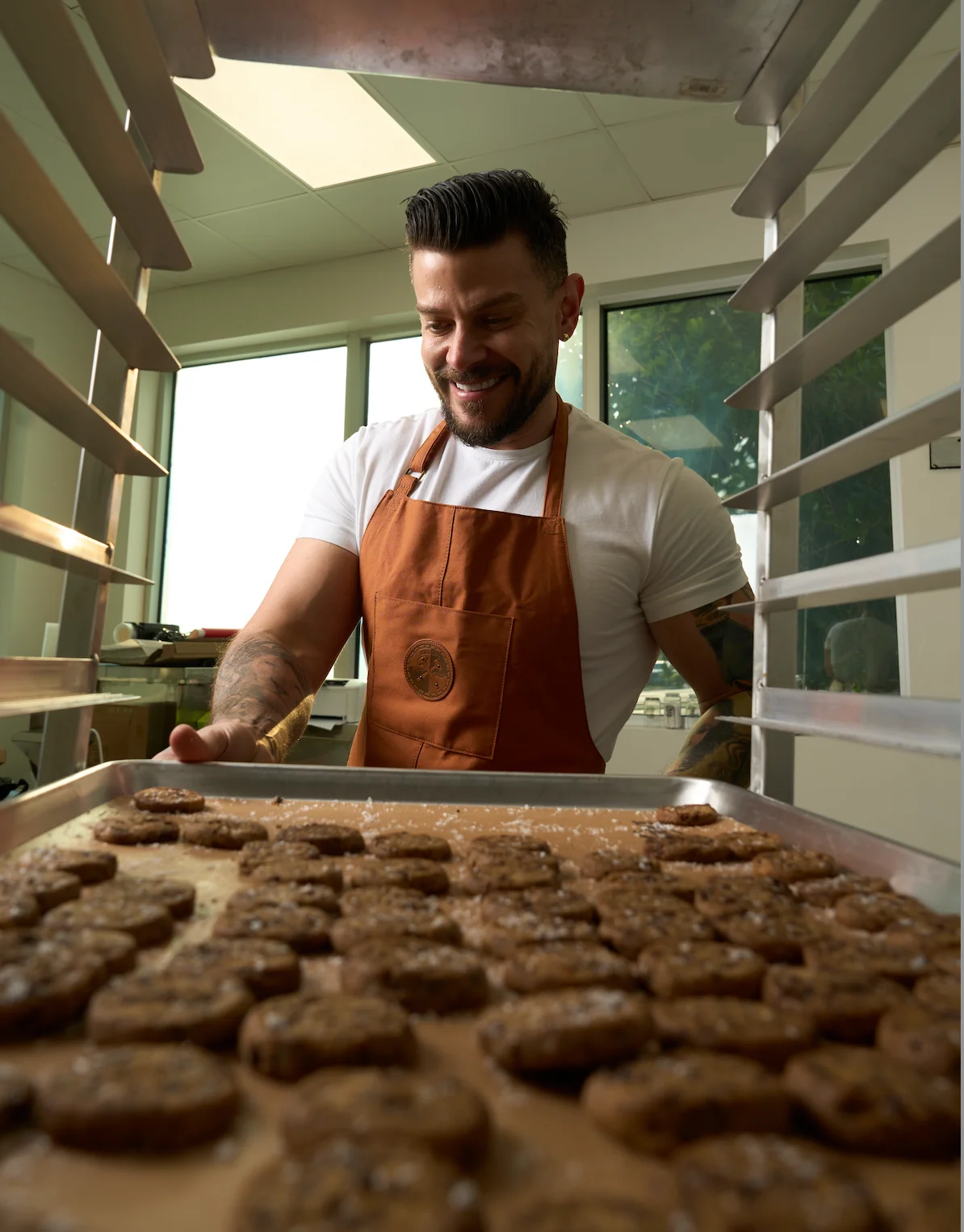 Baker preparing fresh chocolate chip cookies in a bright kitchen