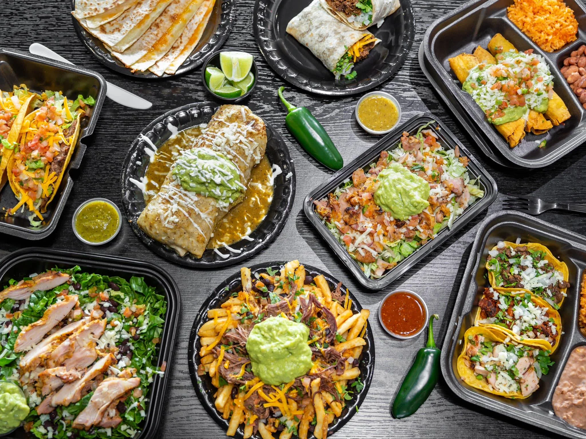 Delicious Mexican feast featuring burritos, tacos, and guacamole