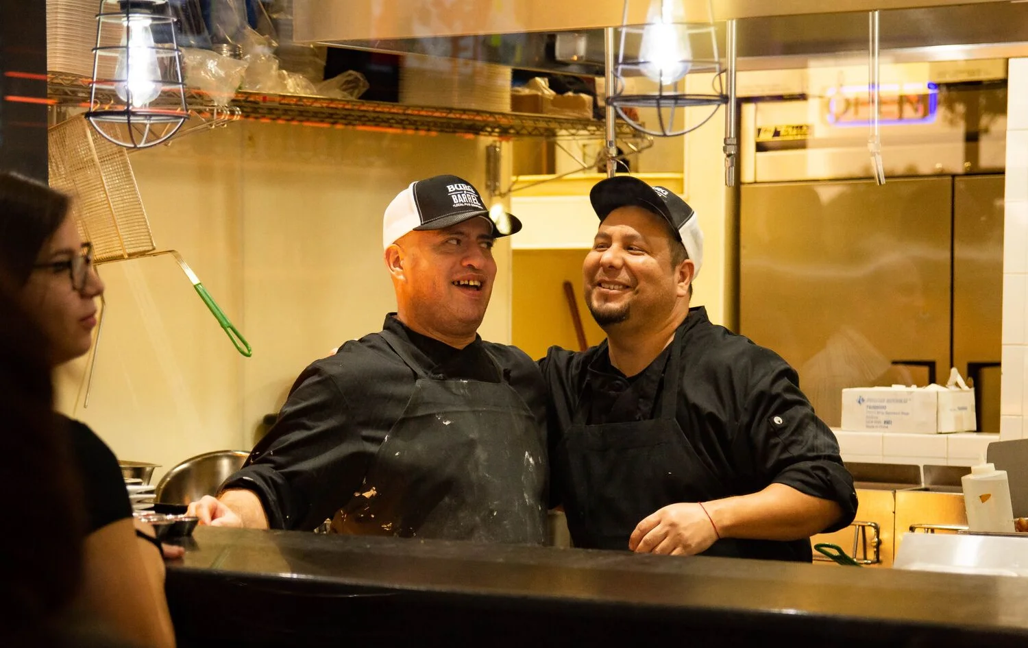 Chefs smiling in a vibrant restaurant kitchen