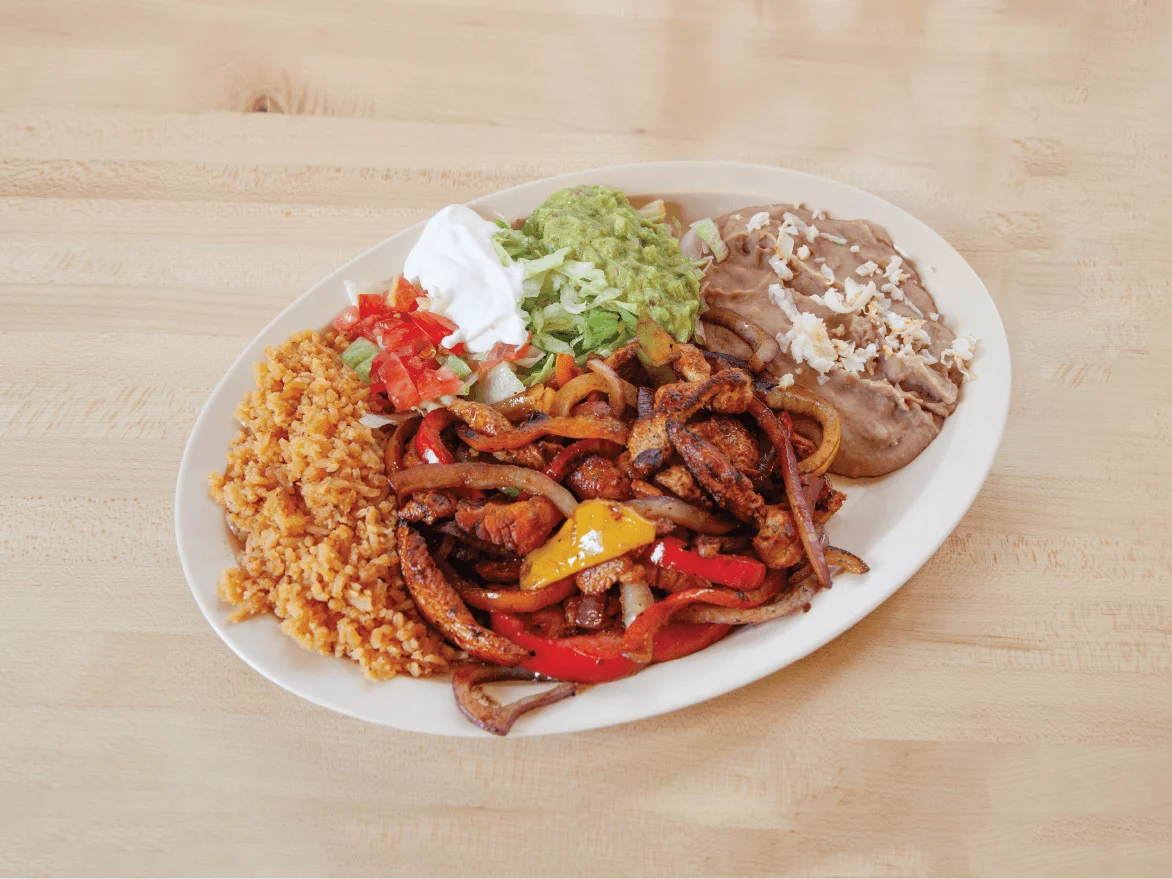 Sizzling fajitas platter with rice and beans