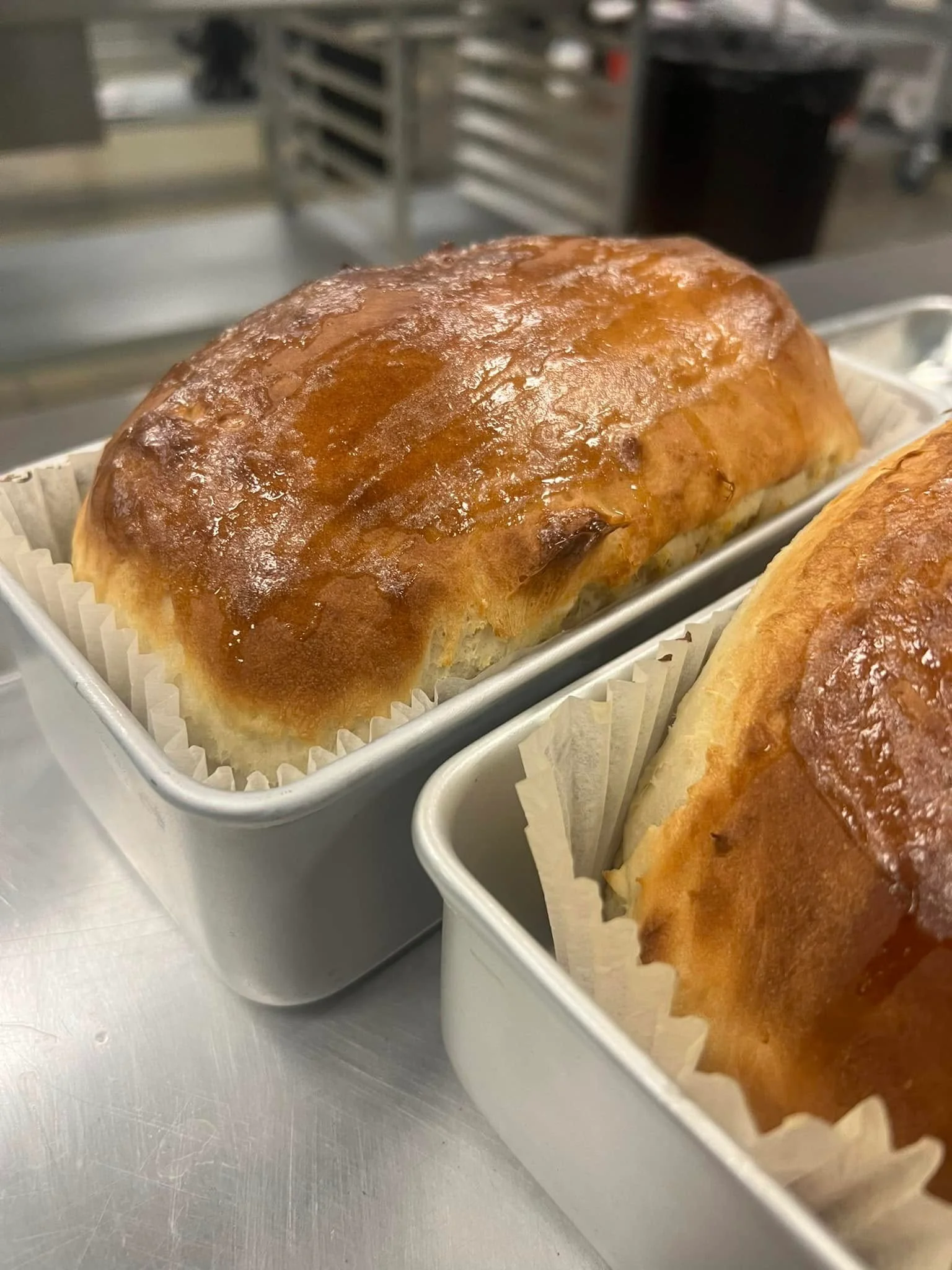 Freshly baked brioche loaves in metal pans