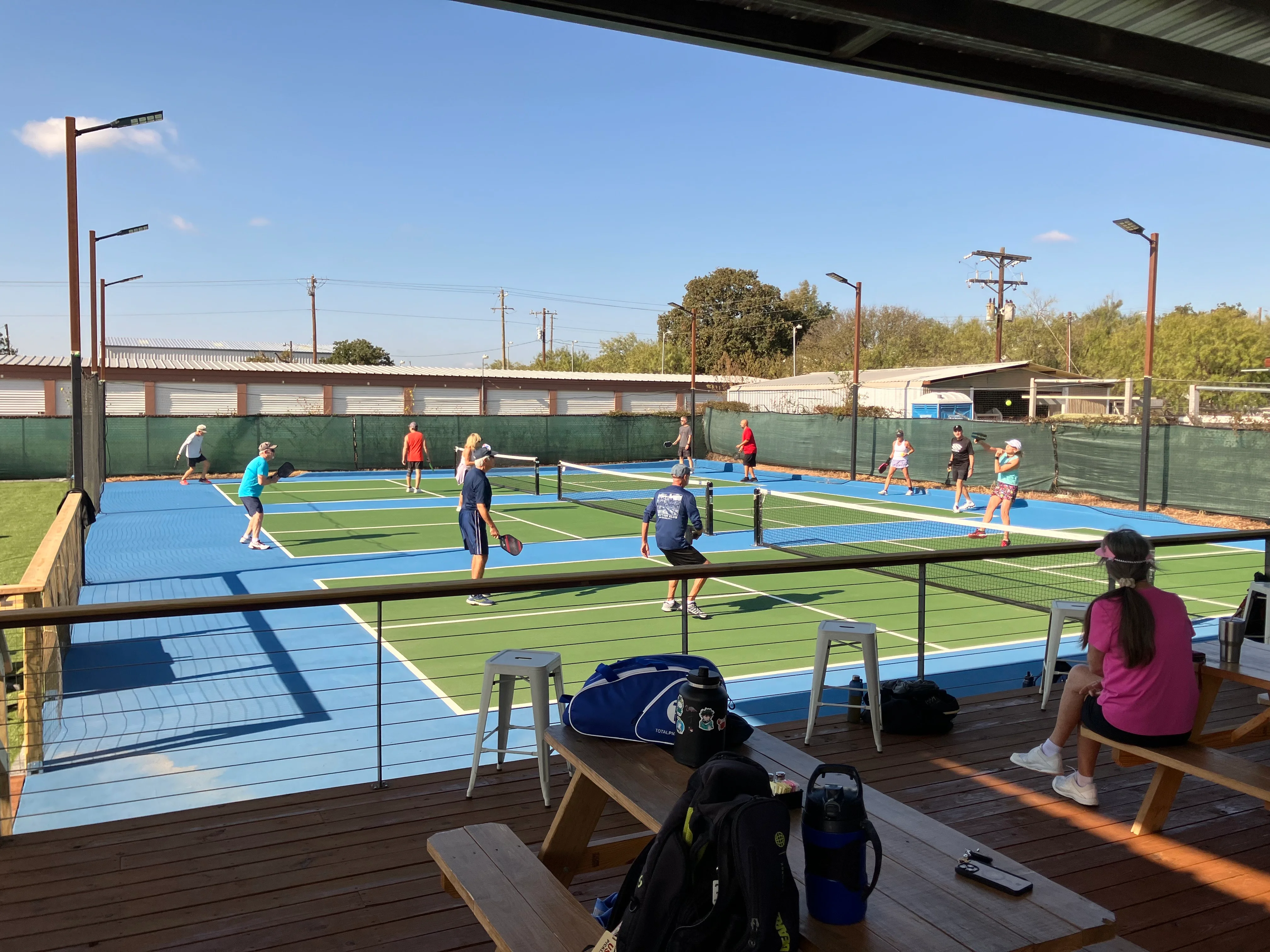 Outdoor tennis courts with players enjoying a sunny day
