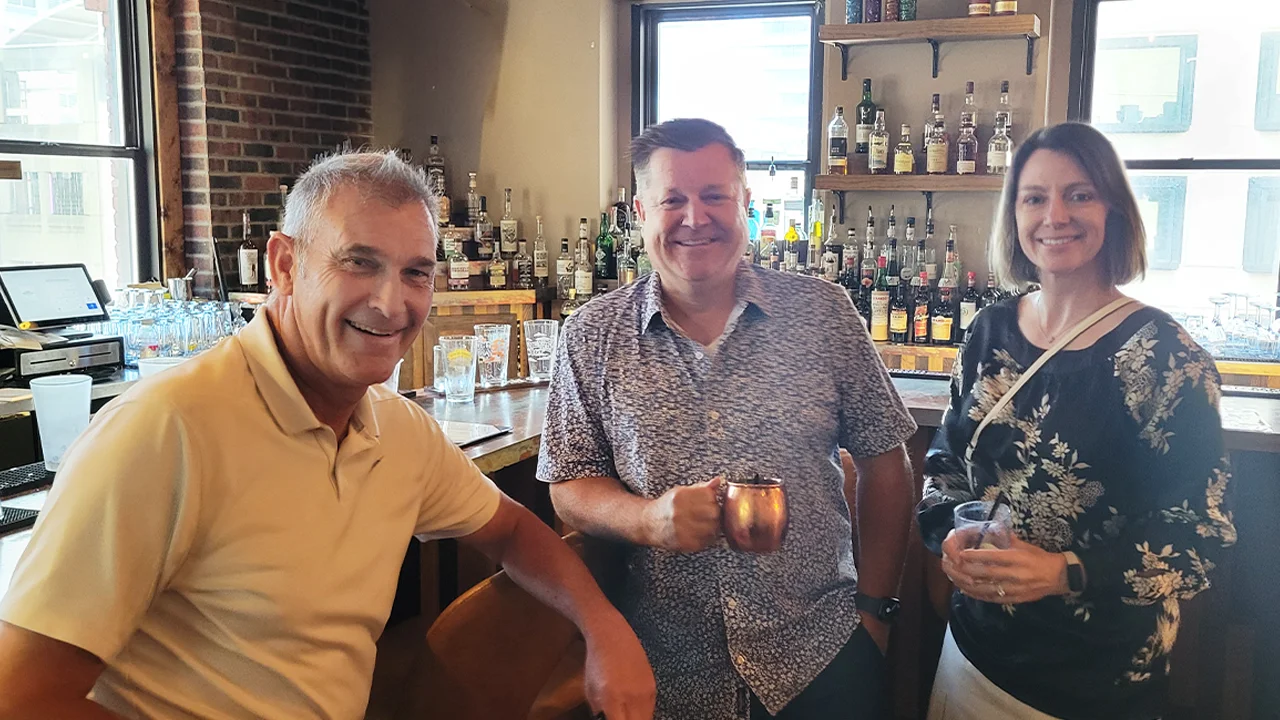 Friends enjoying drinks at a stylish bar with a vibrant atmosphere