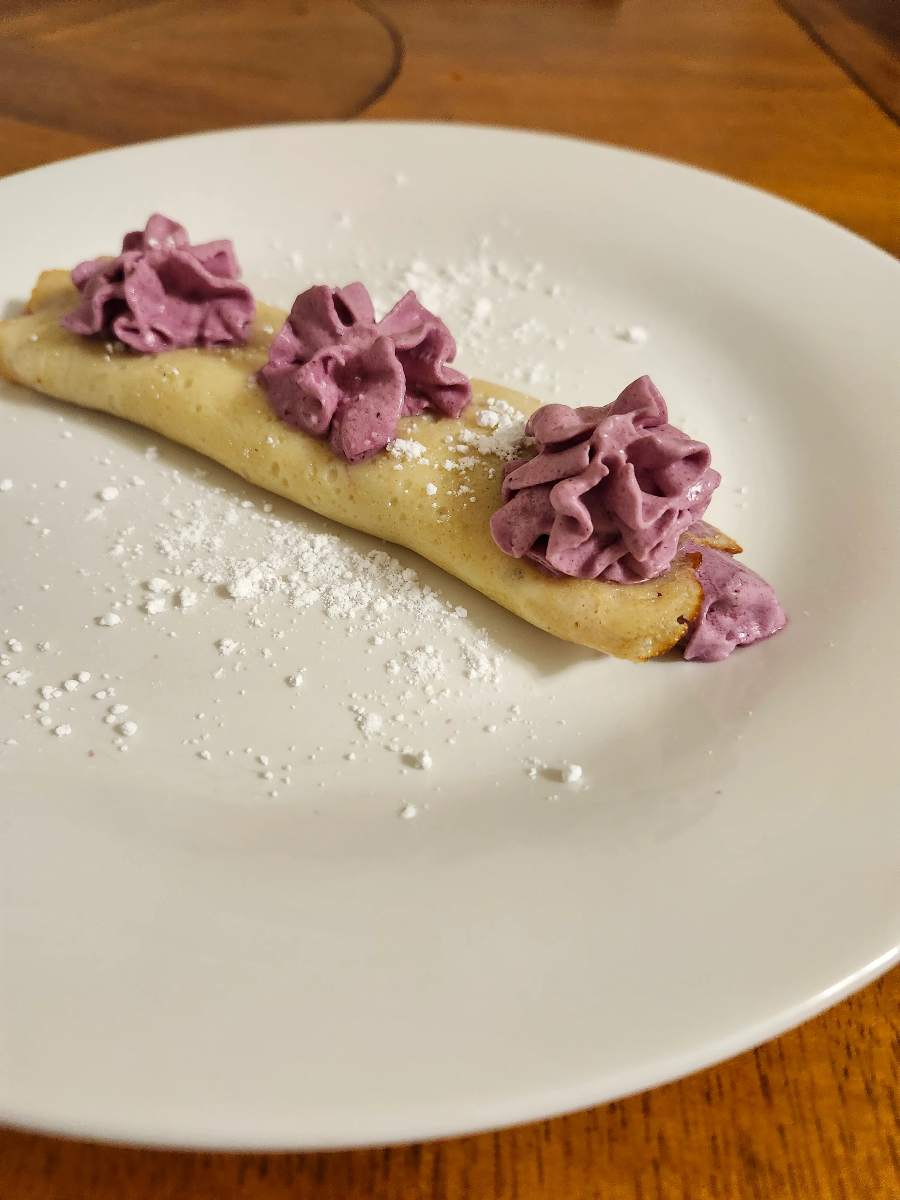 Delicious French crêpe filled with purple cream and dusted with powdered sugar