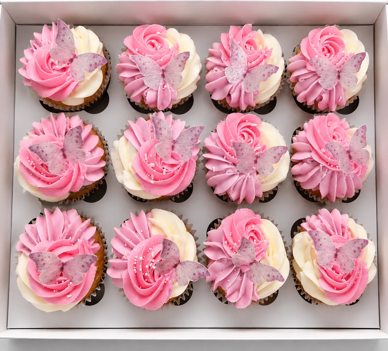 Decorative pink and white cupcakes with butterfly toppers