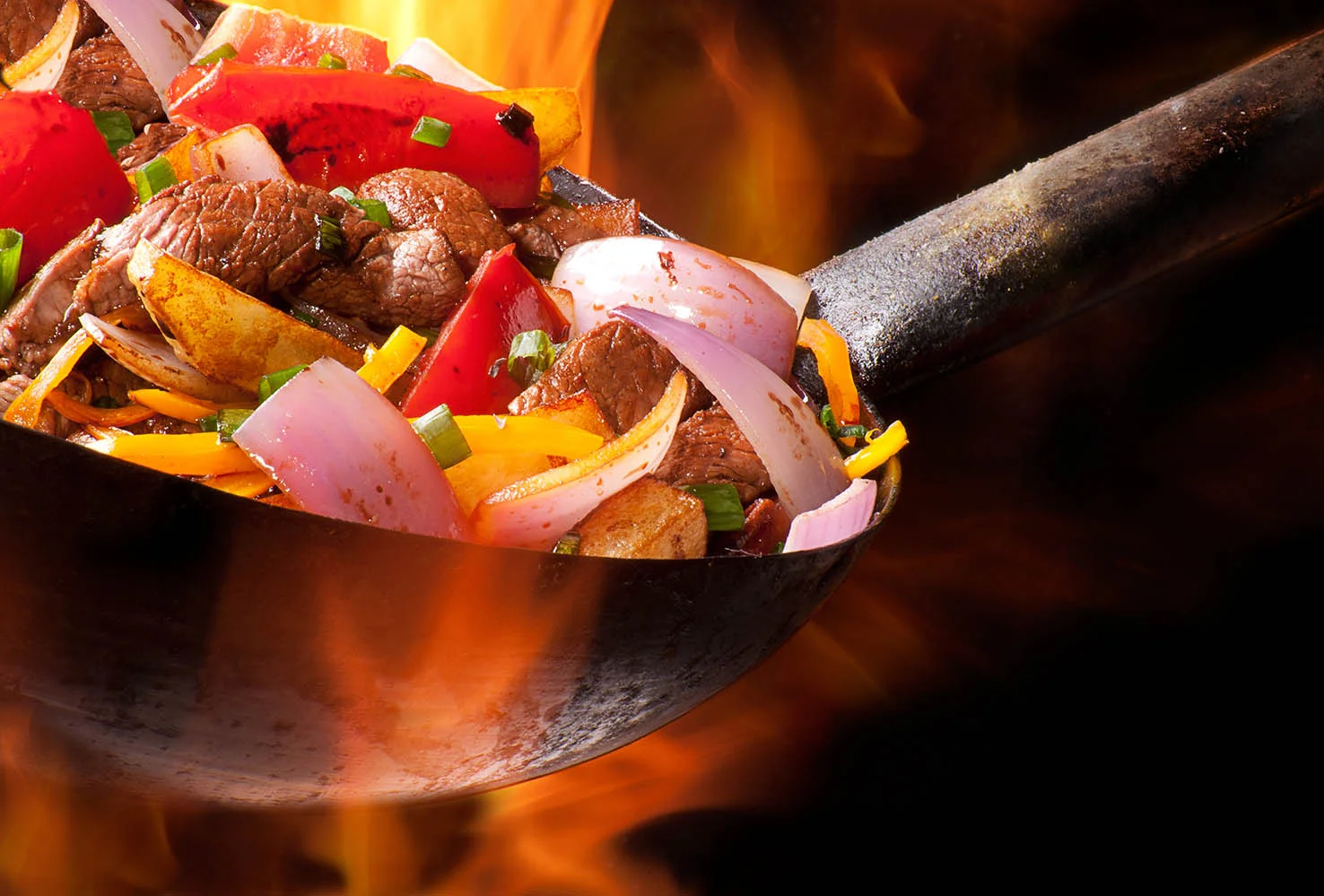 Sizzling beef stir-fry in a wok with colorful vegetables