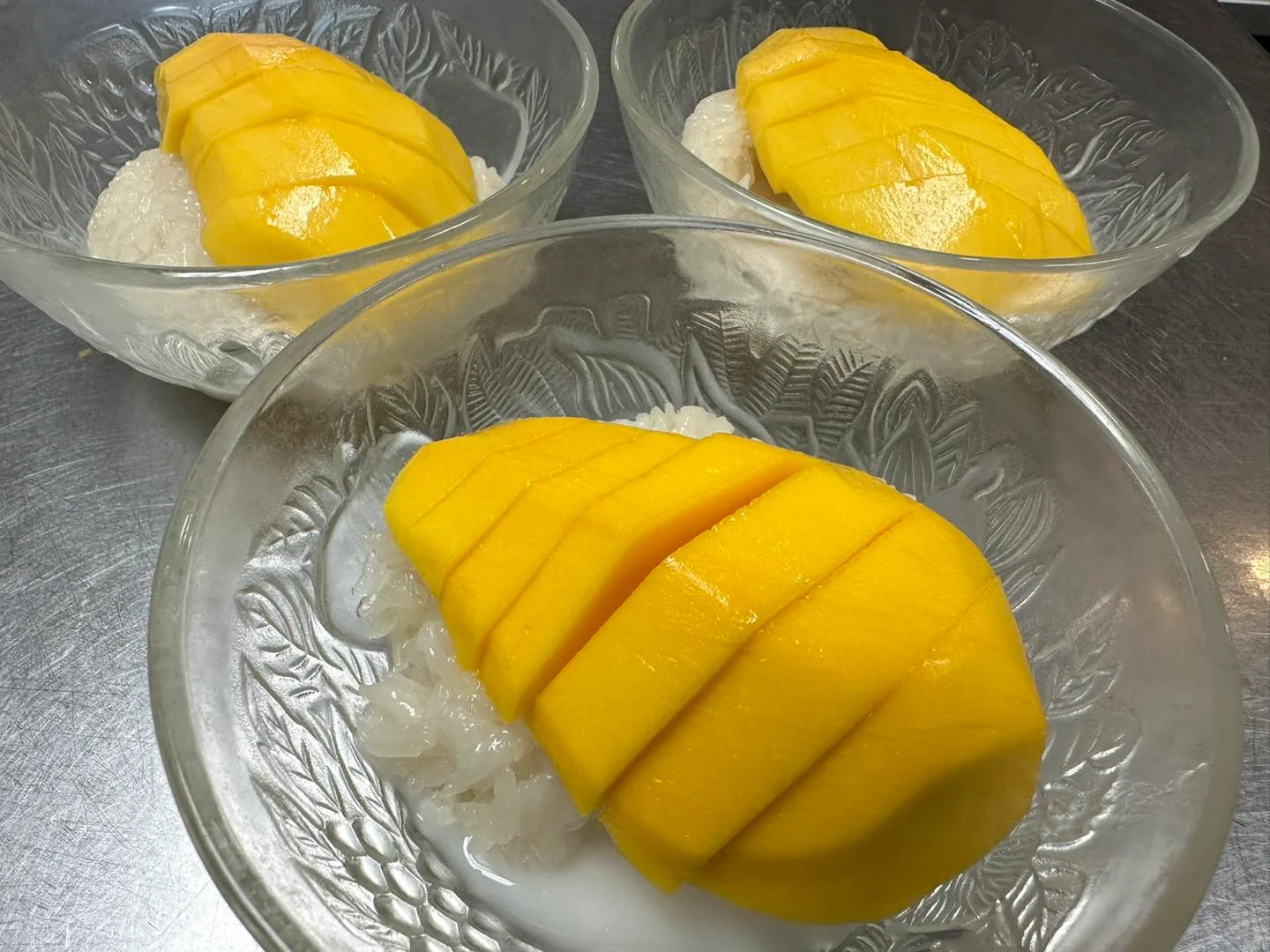 Thai mango sticky rice dessert served in glass bowls