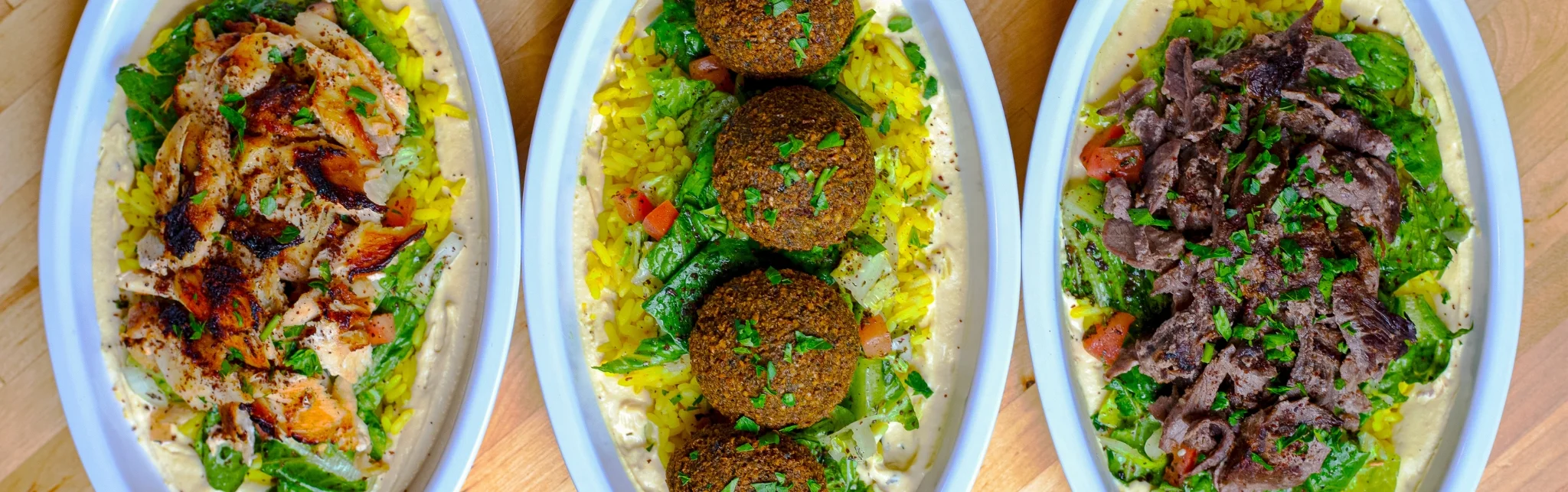 Mediterranean platter with chicken, falafel, and beef over rice