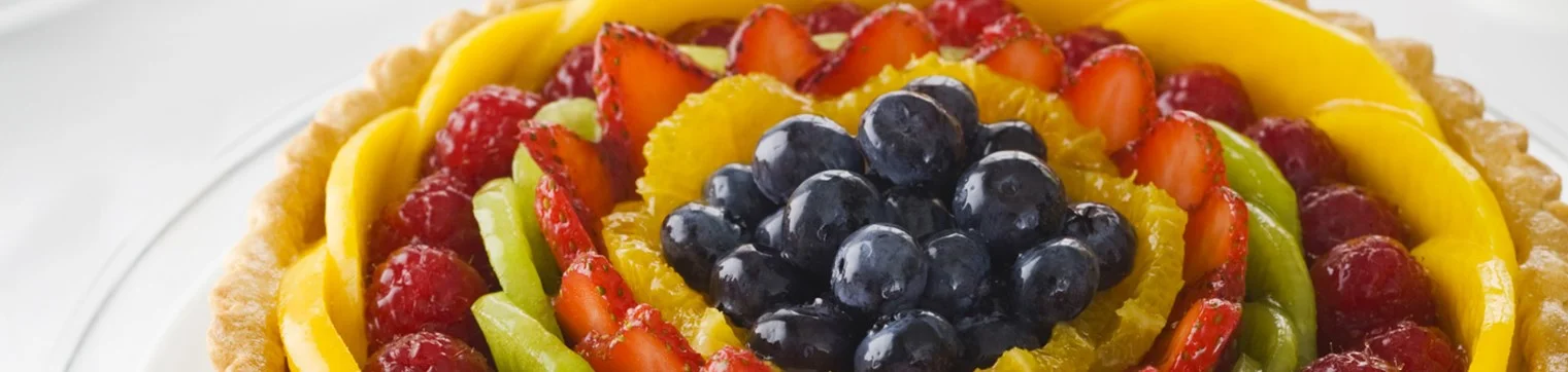 Colorful fruit tart with seasonal berries and tropical fruits