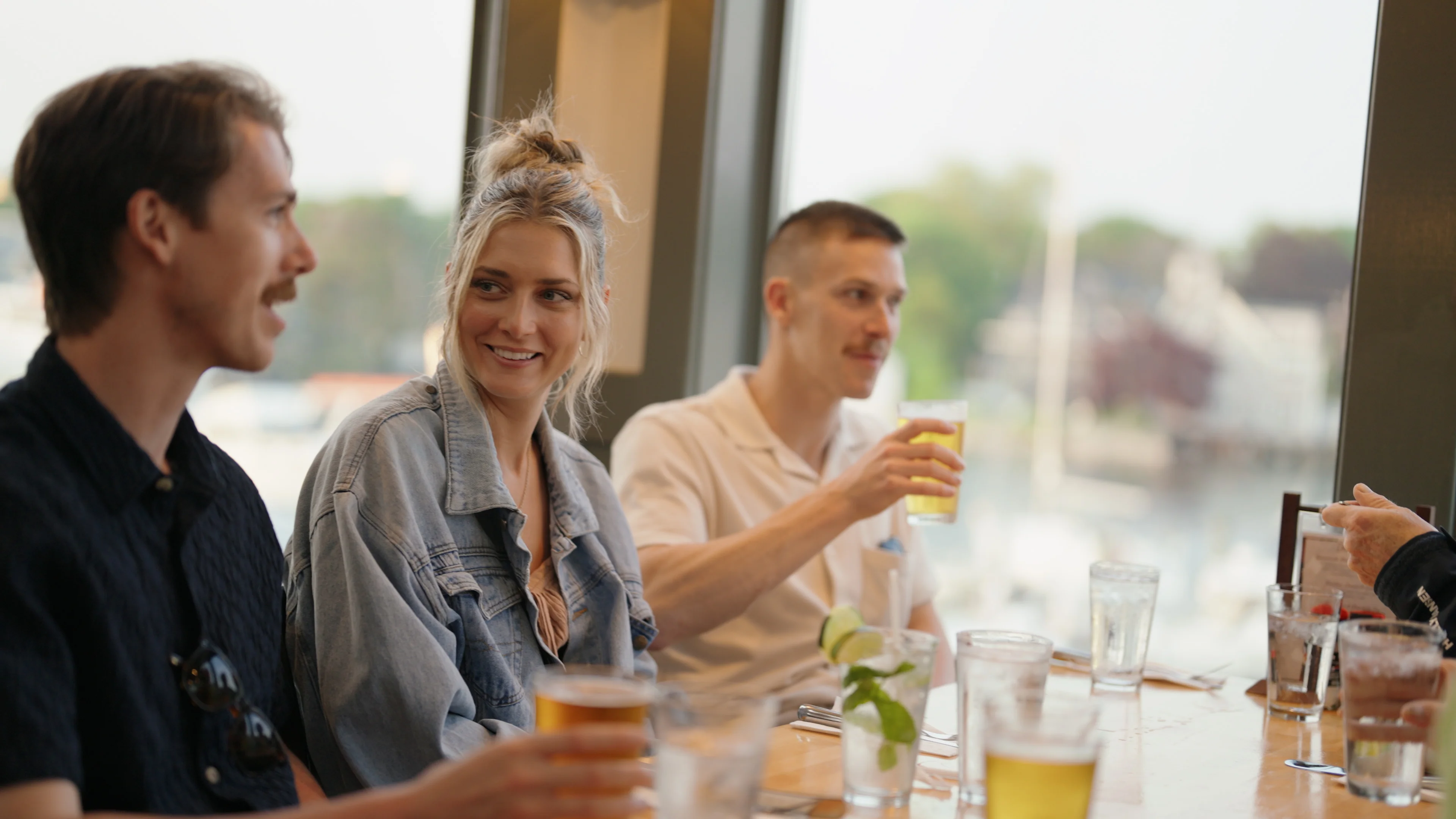 Group of friends enjoying drinks at a restaurant with a scenic view