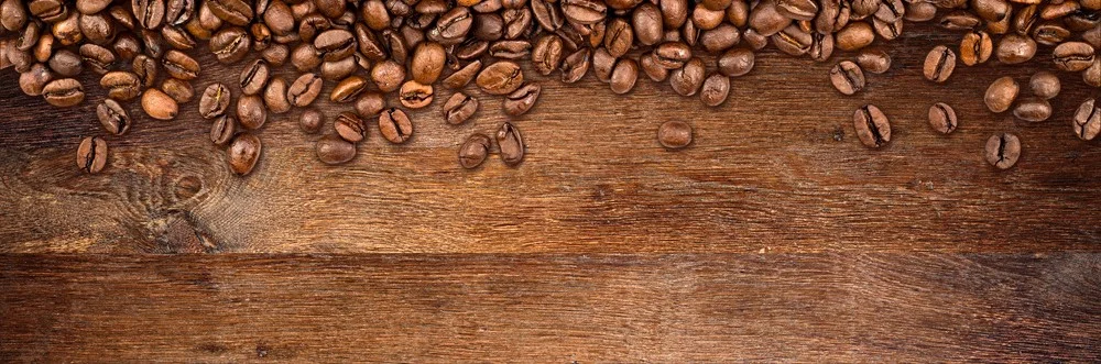 Freshly roasted coffee beans on wooden surface