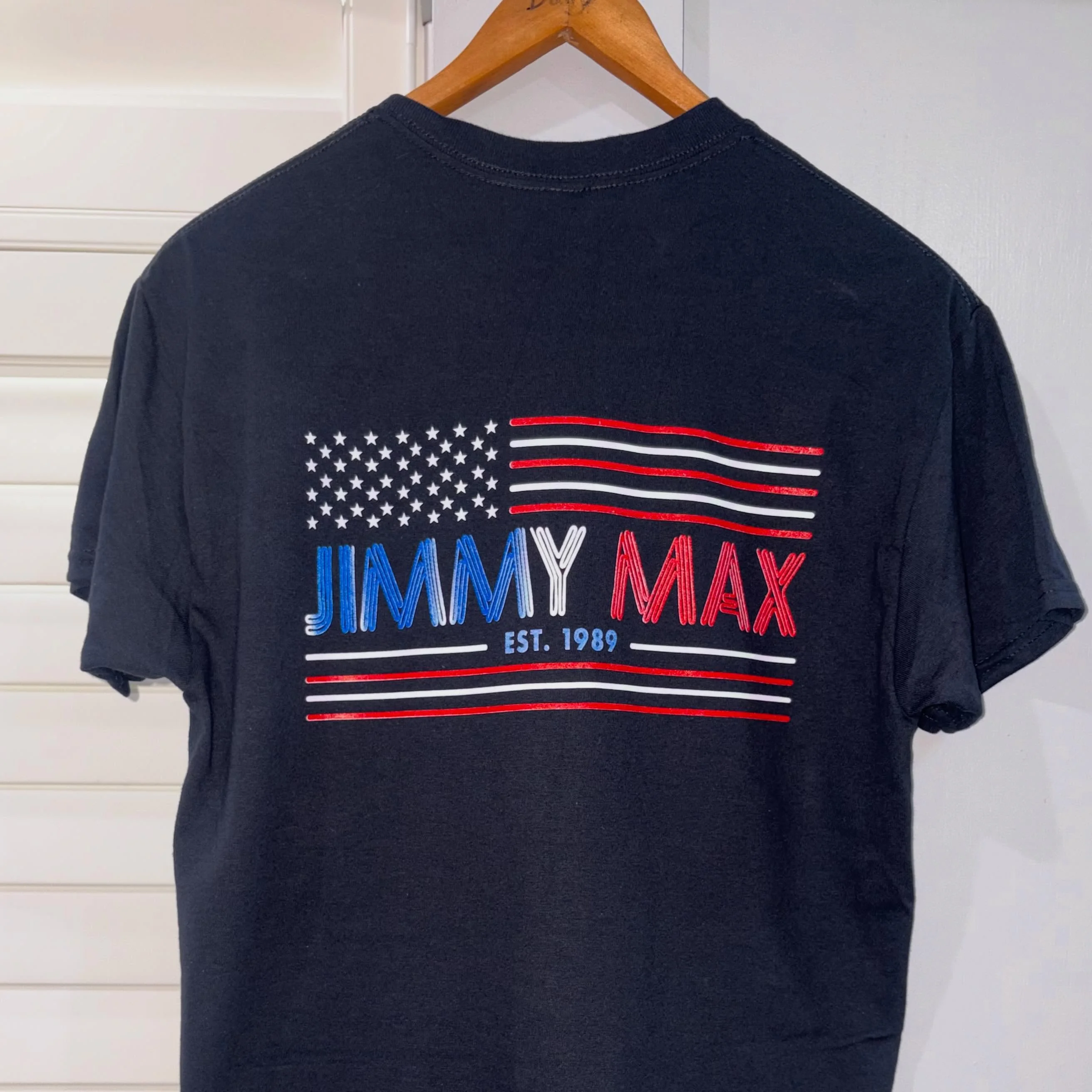 Black t-shirt featuring American flag design and brand logo