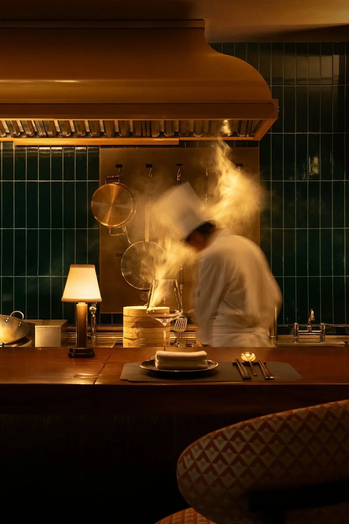 Chef preparing dishes in a modern kitchen with steam rising