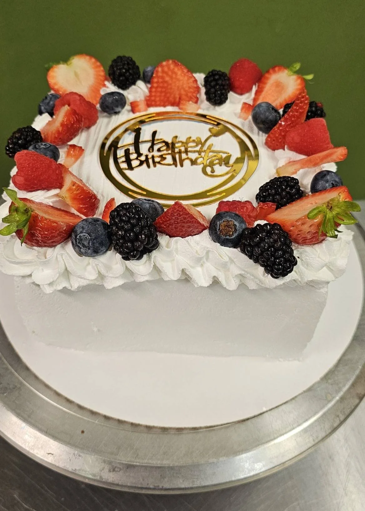 Decorative birthday cake topped with fresh berries