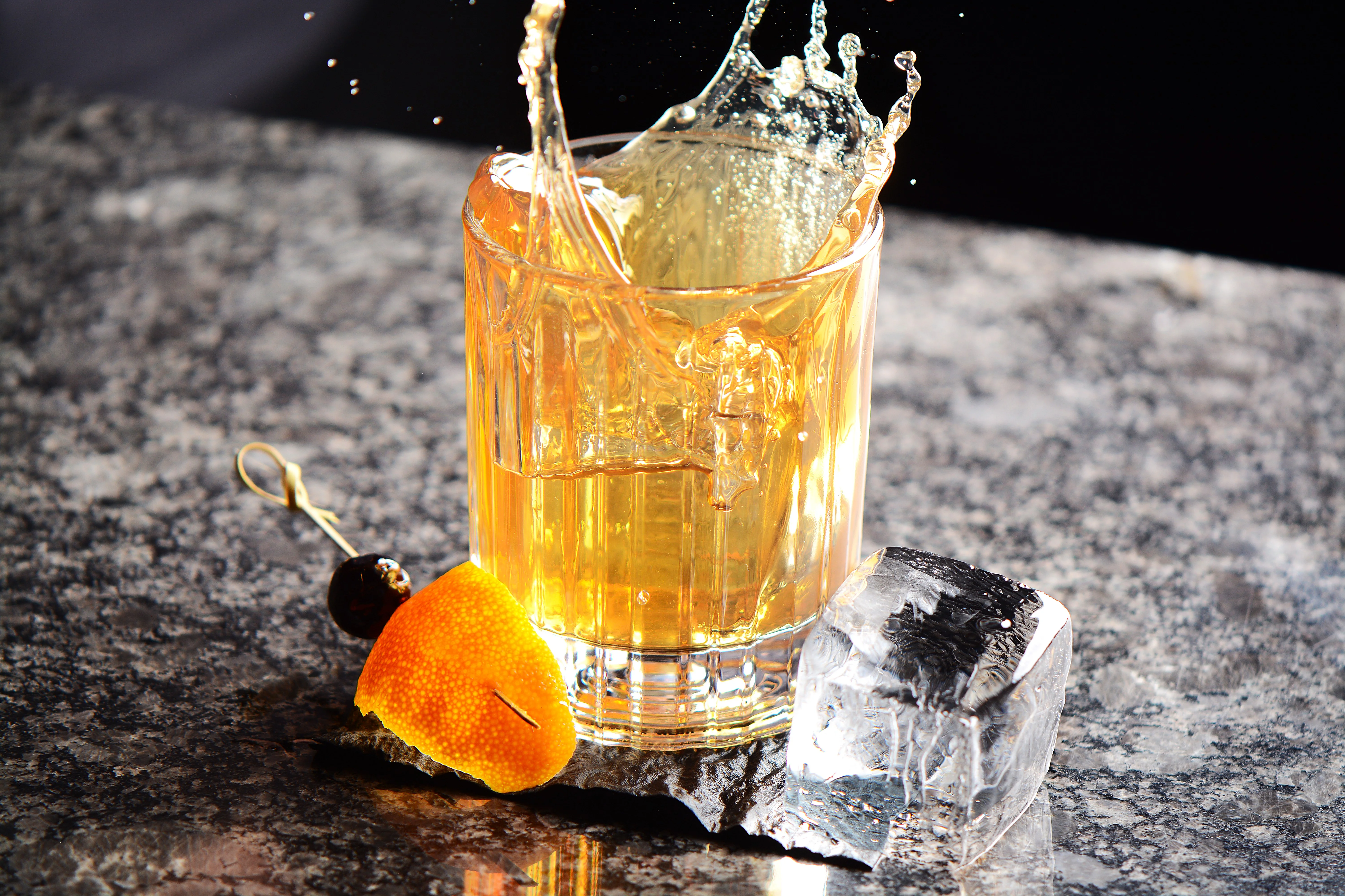 Classic whiskey cocktail with splash and garnishes