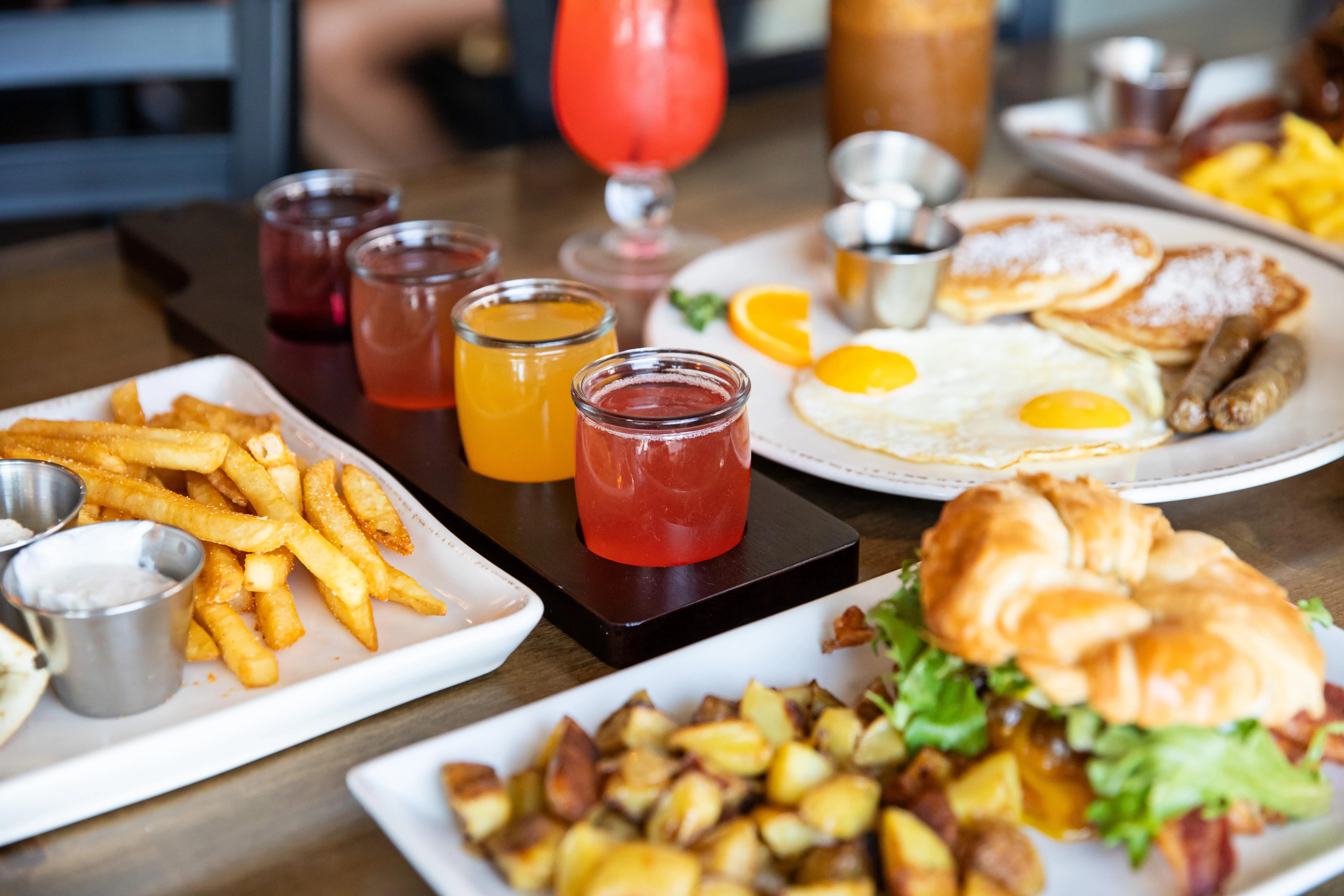 Brunch spread featuring eggs, pancakes, and colorful drinks