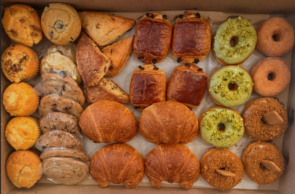 Assorted pastries and donuts in a bakery box