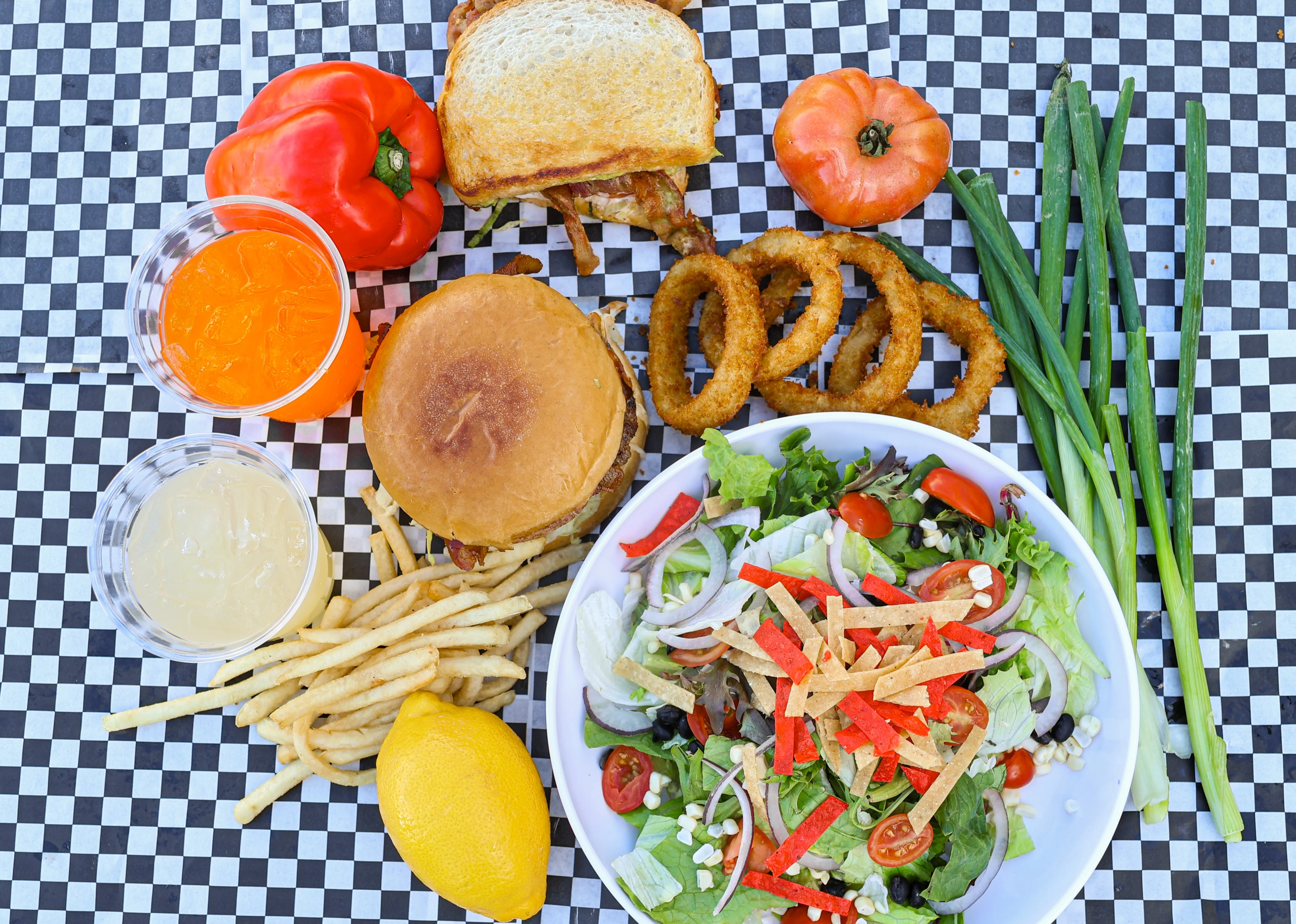 Colorful American diner meal with salad, burger, and sides