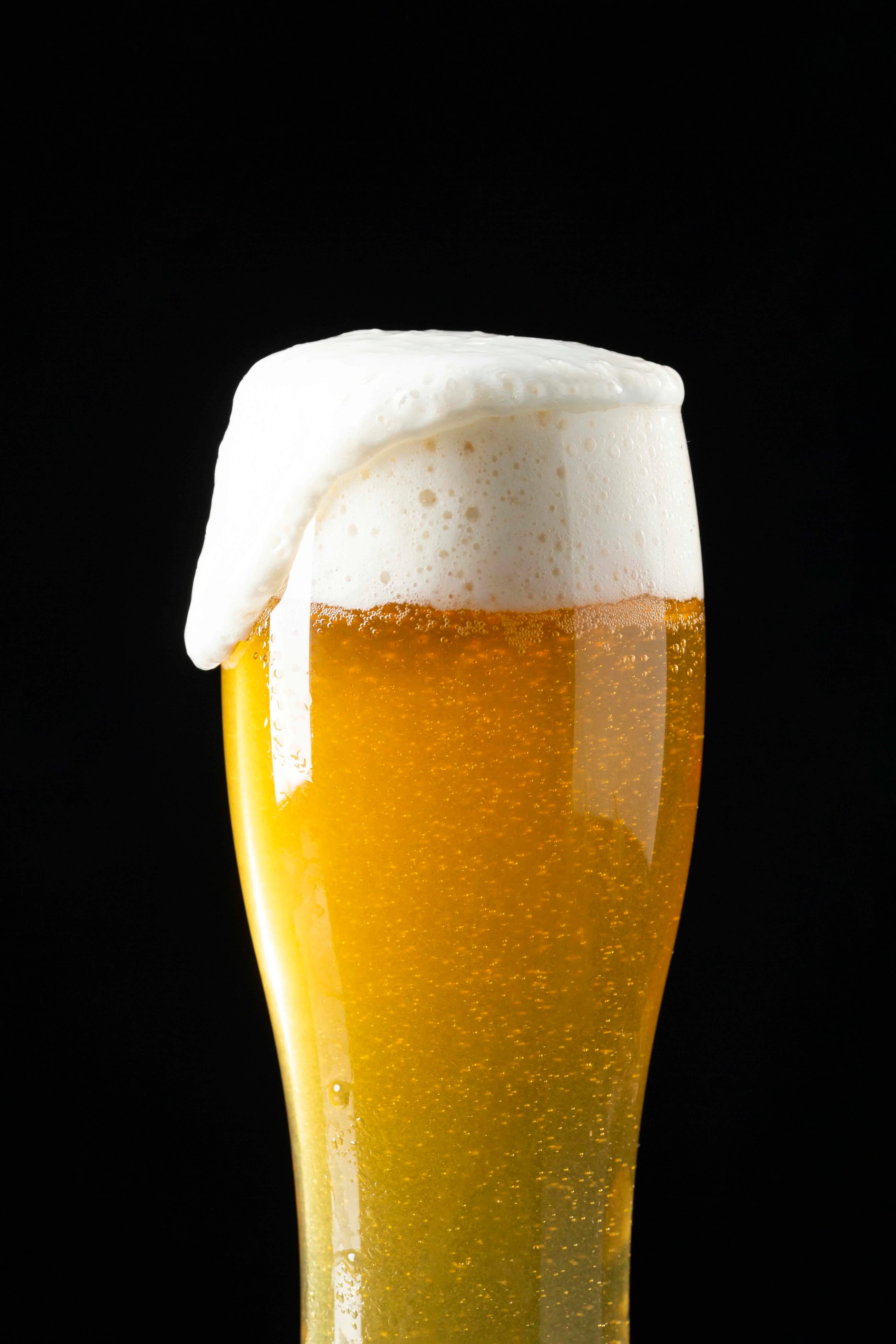 Chilled glass of golden beer with frothy head