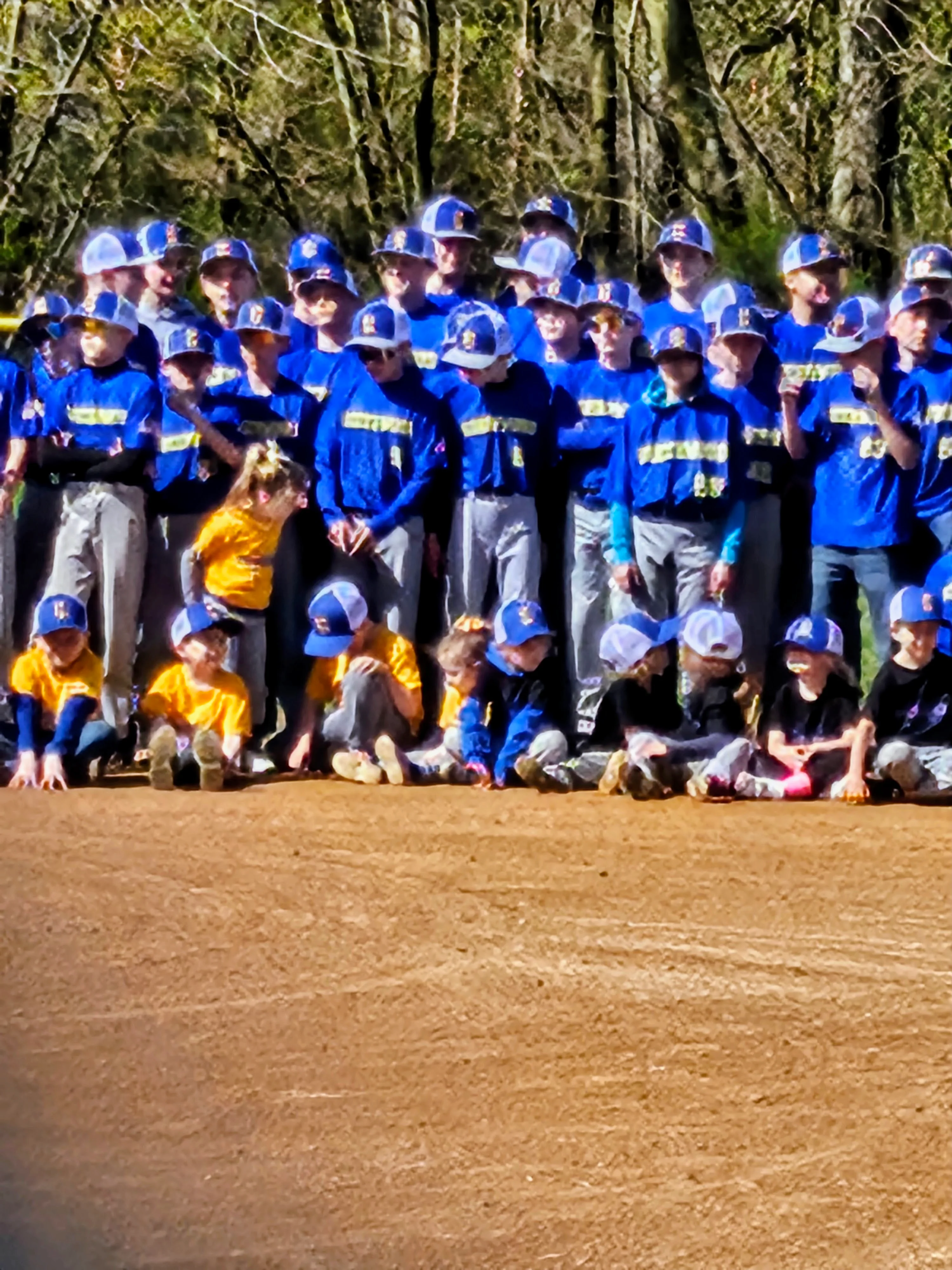 Youth baseball team posing for a group photo on the field