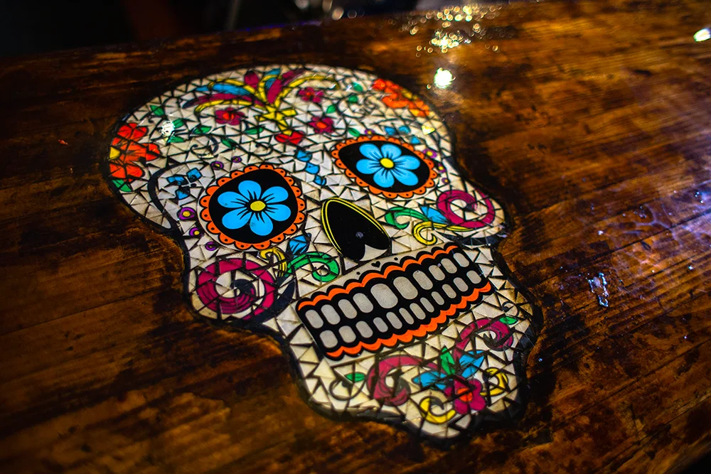 Colorful sugar skull design on a wooden bar top