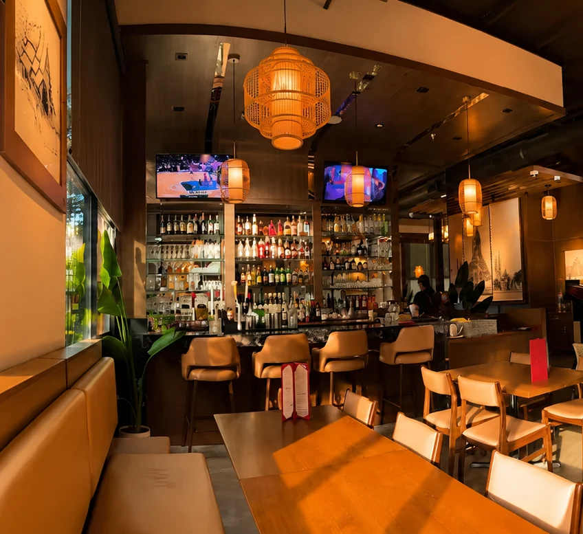 Modern restaurant interior with warm lighting and bar area