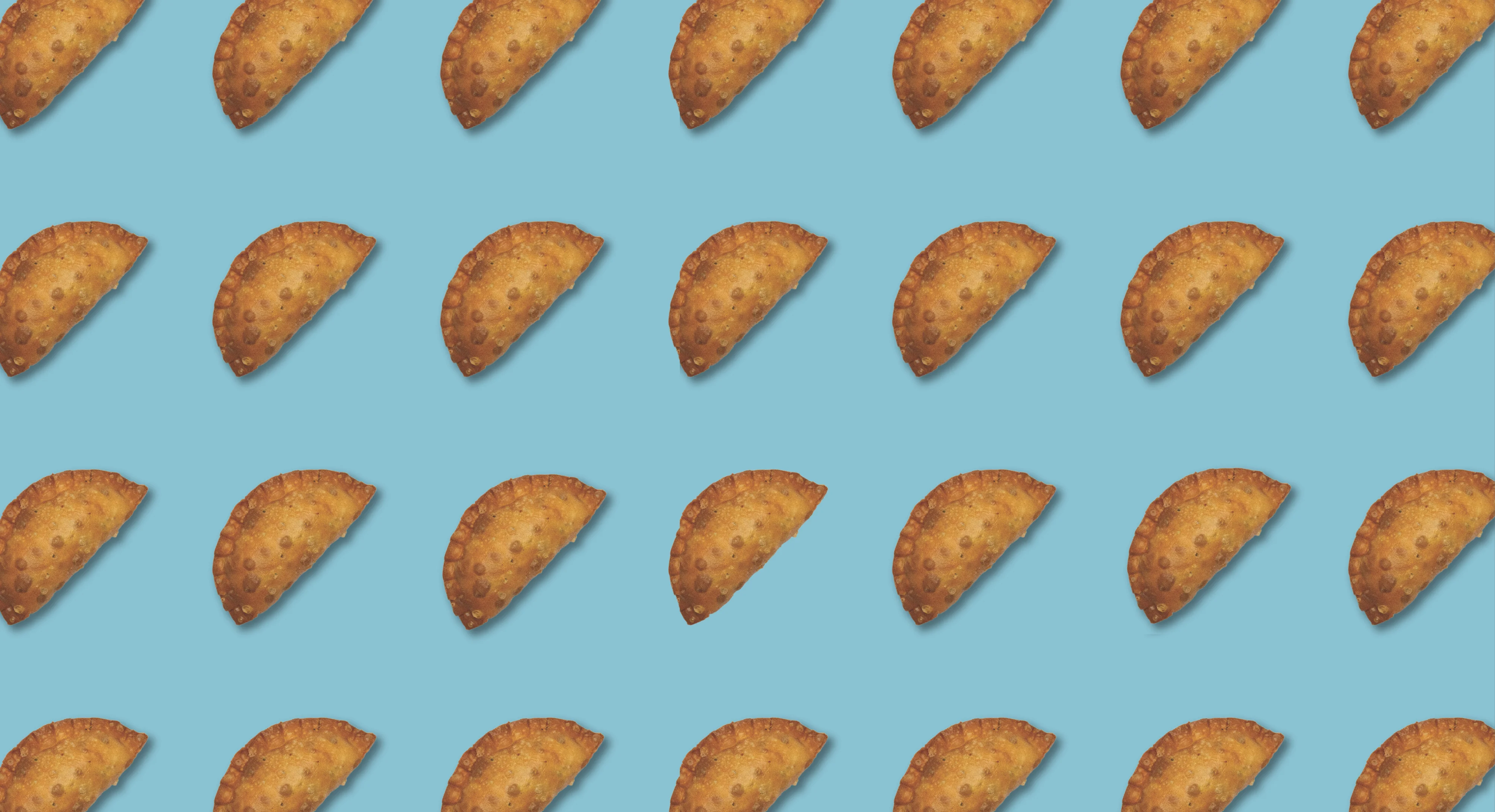 Golden empanadas on a turquoise background