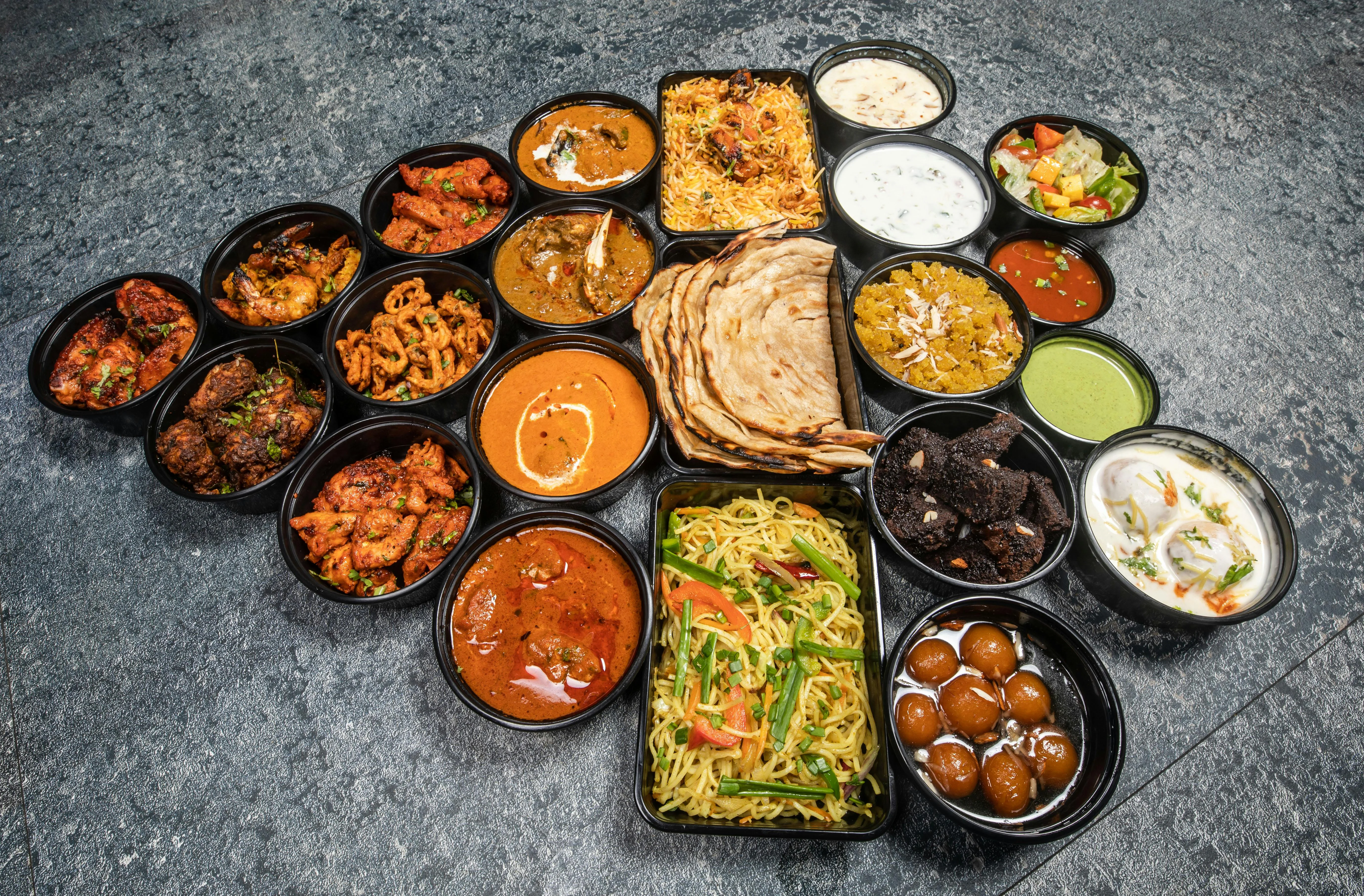 Assorted Indian dishes including biryani, curries, and naan bread
