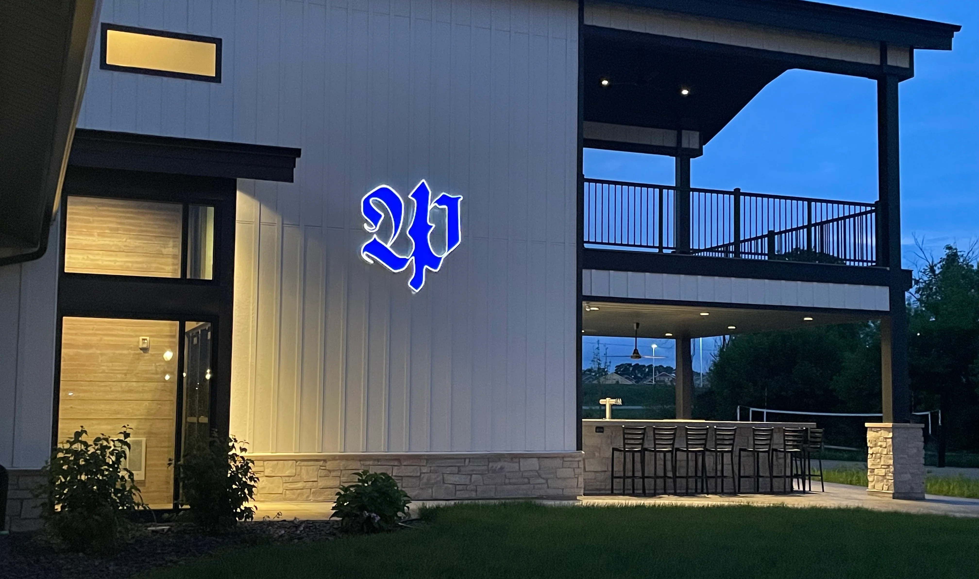 Modern restaurant exterior with illuminated signage at dusk