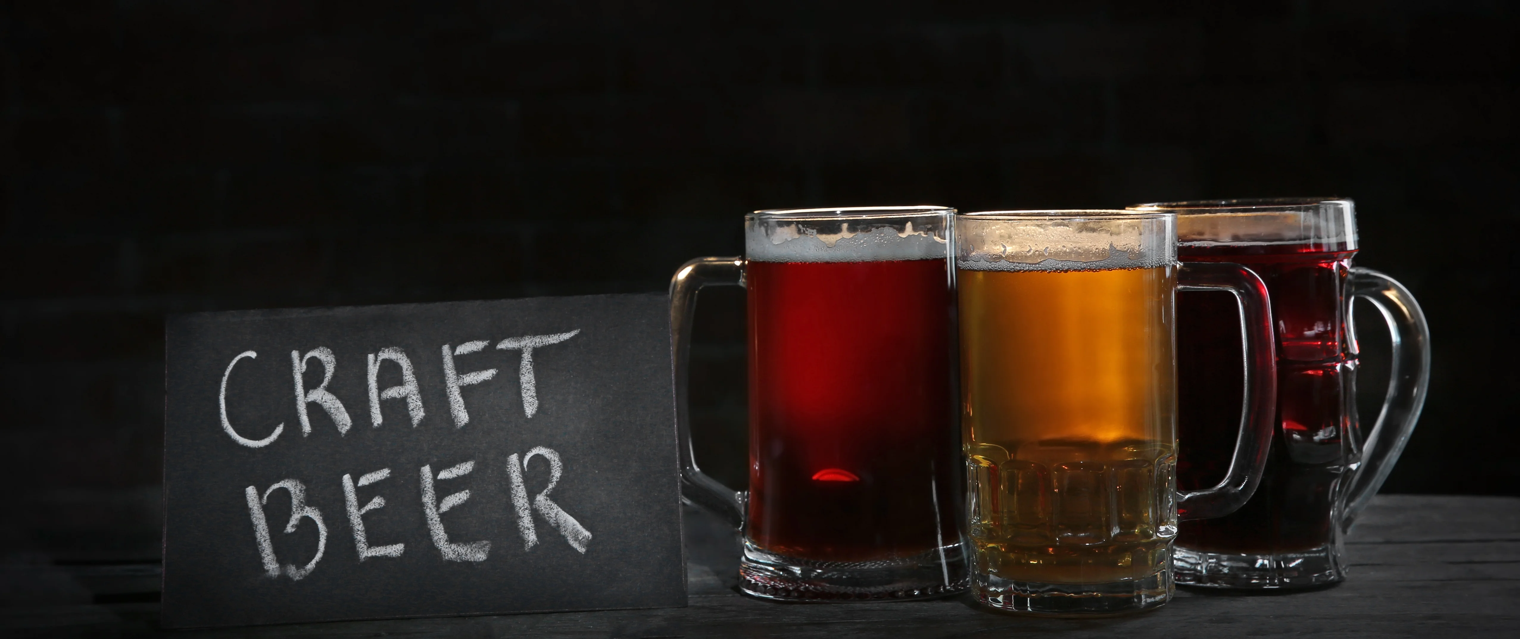 Selection of craft beers in mugs with a chalkboard sign