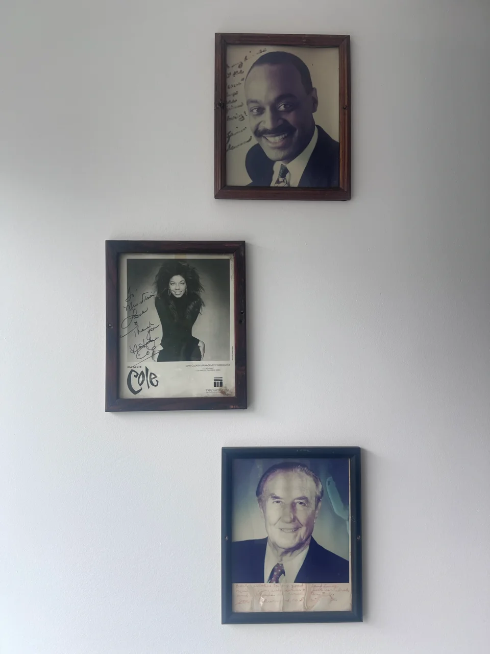 Framed vintage portraits and autographed photographs on a restaurant wall